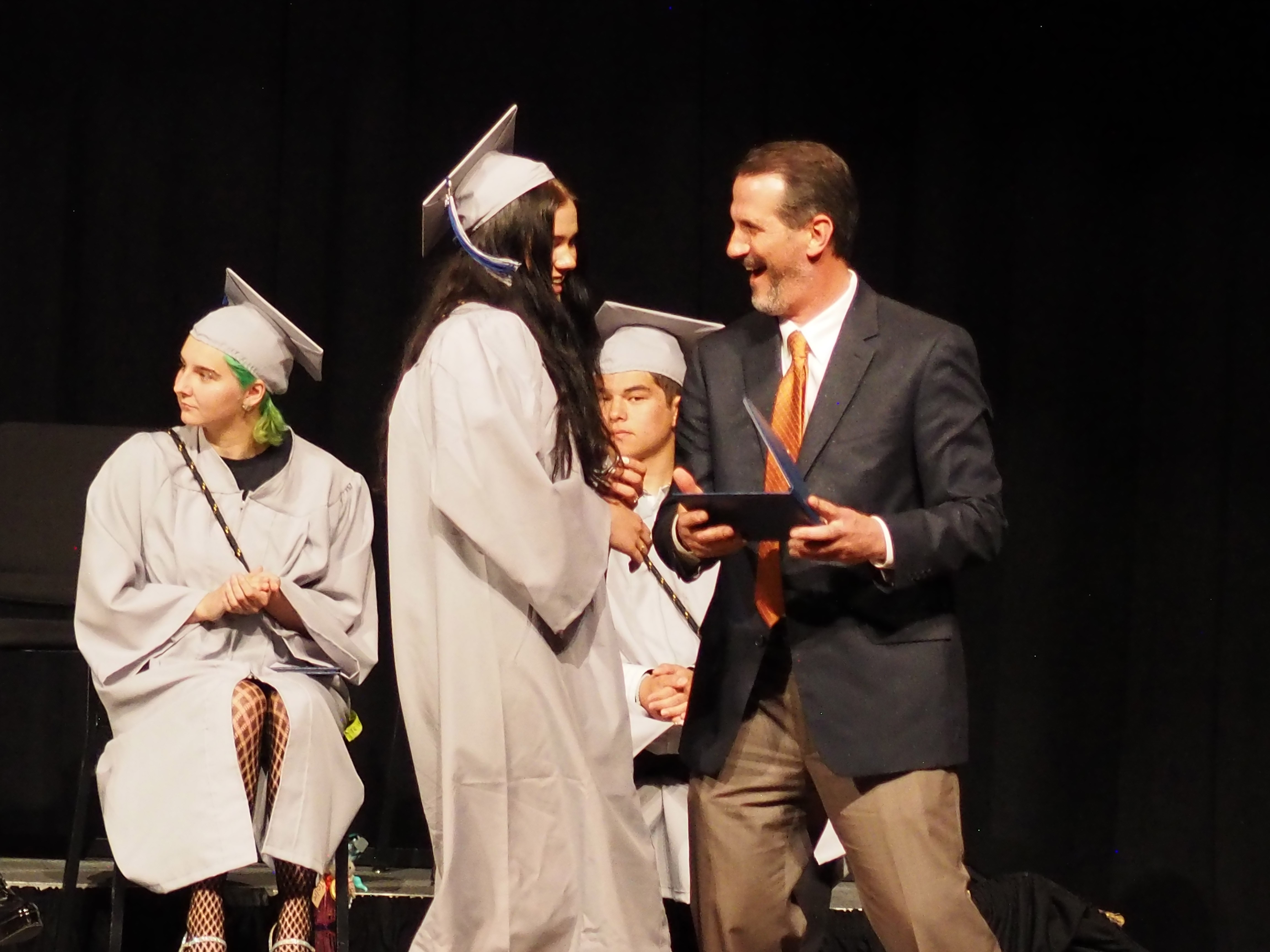 The Polaris principal presents a diploma to a graduate. 