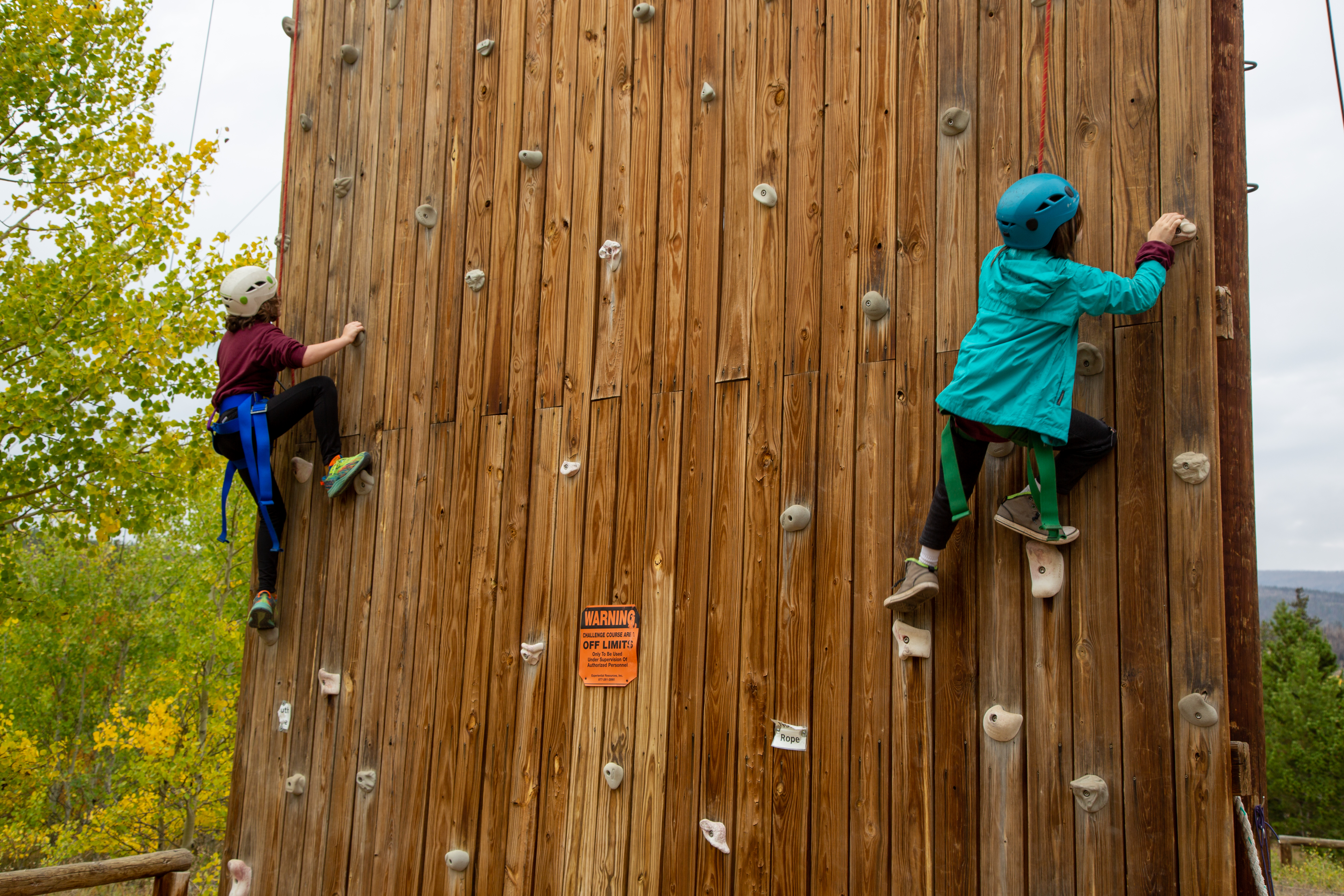 Students on the climbing wall make their way higher. 