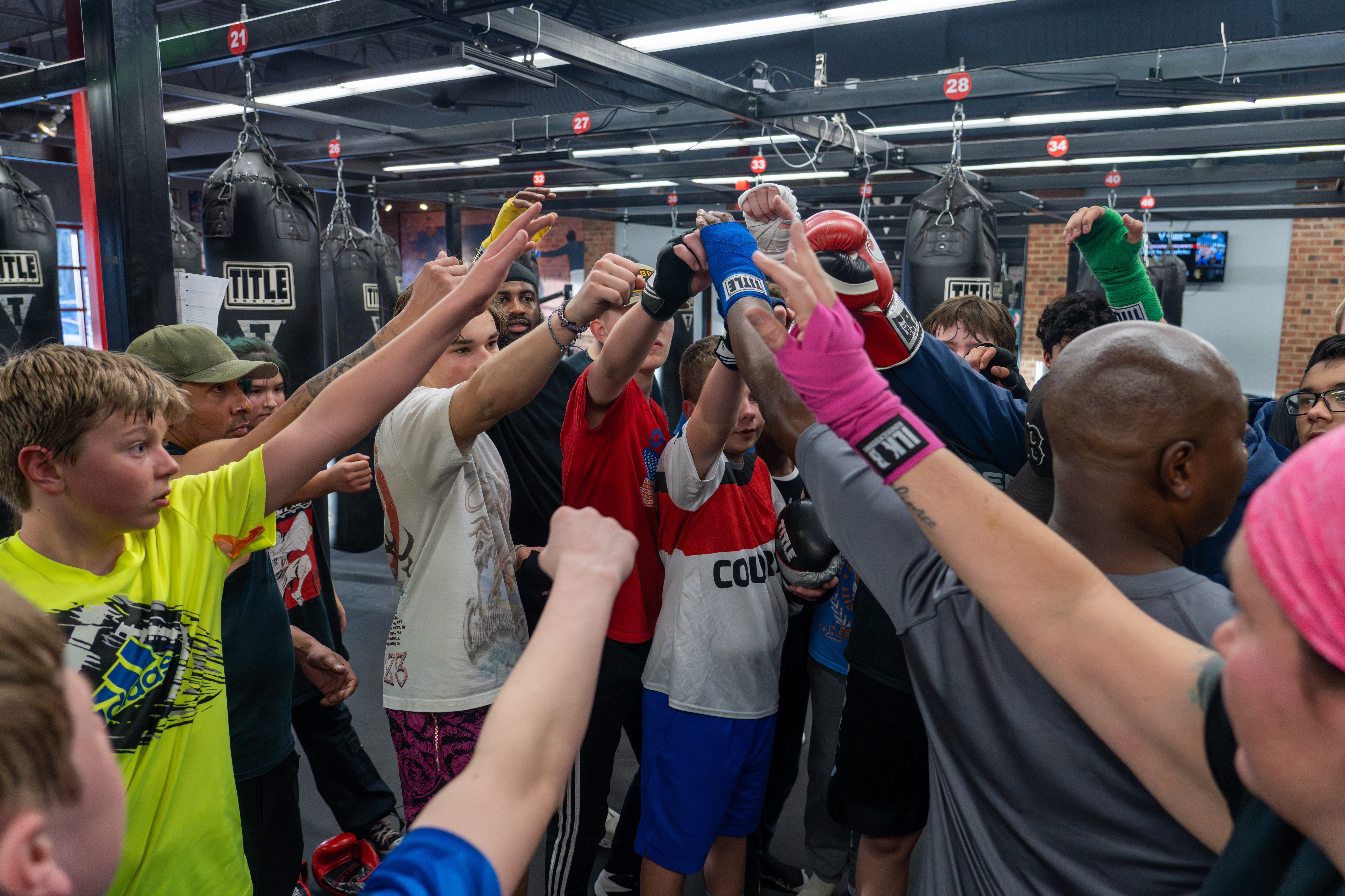 Boltz Boxing Club members support each other with a group high five.