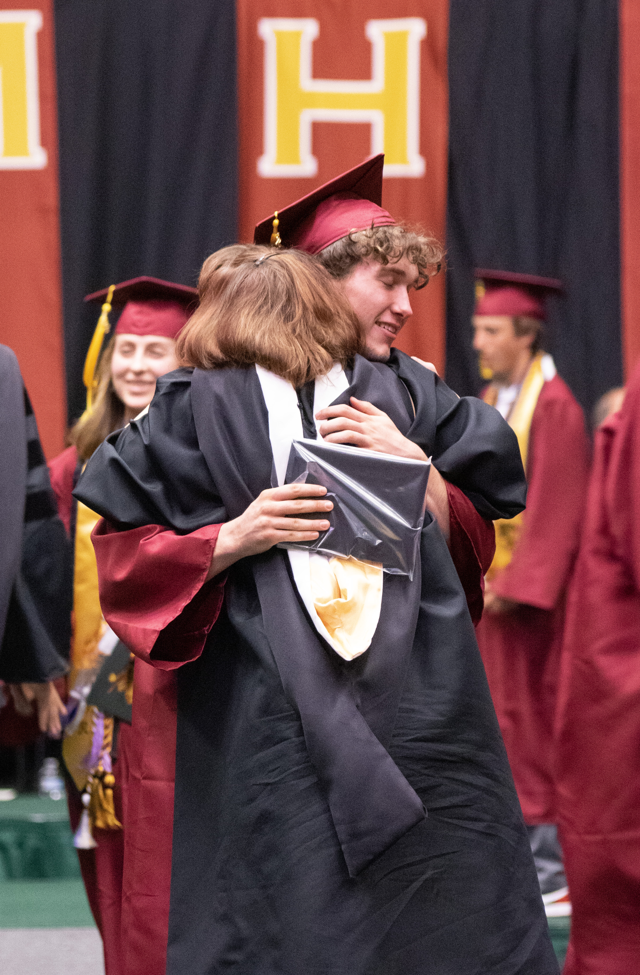 A Rocky Mountain High School grad hugs a RMHS staff person. 