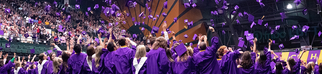 Fort Collins High School graduates throw caps in the air.
