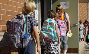 Elementary kids walking into a school.