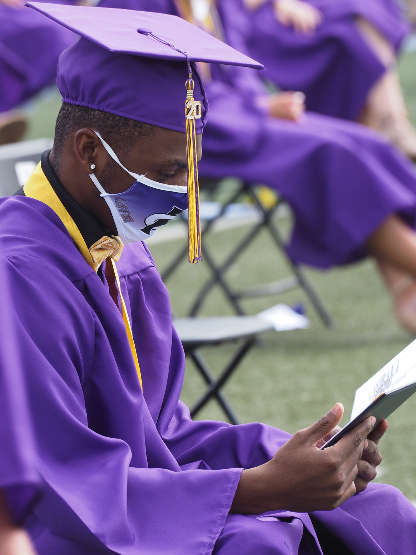 FCHS graduate looking at his diploma.