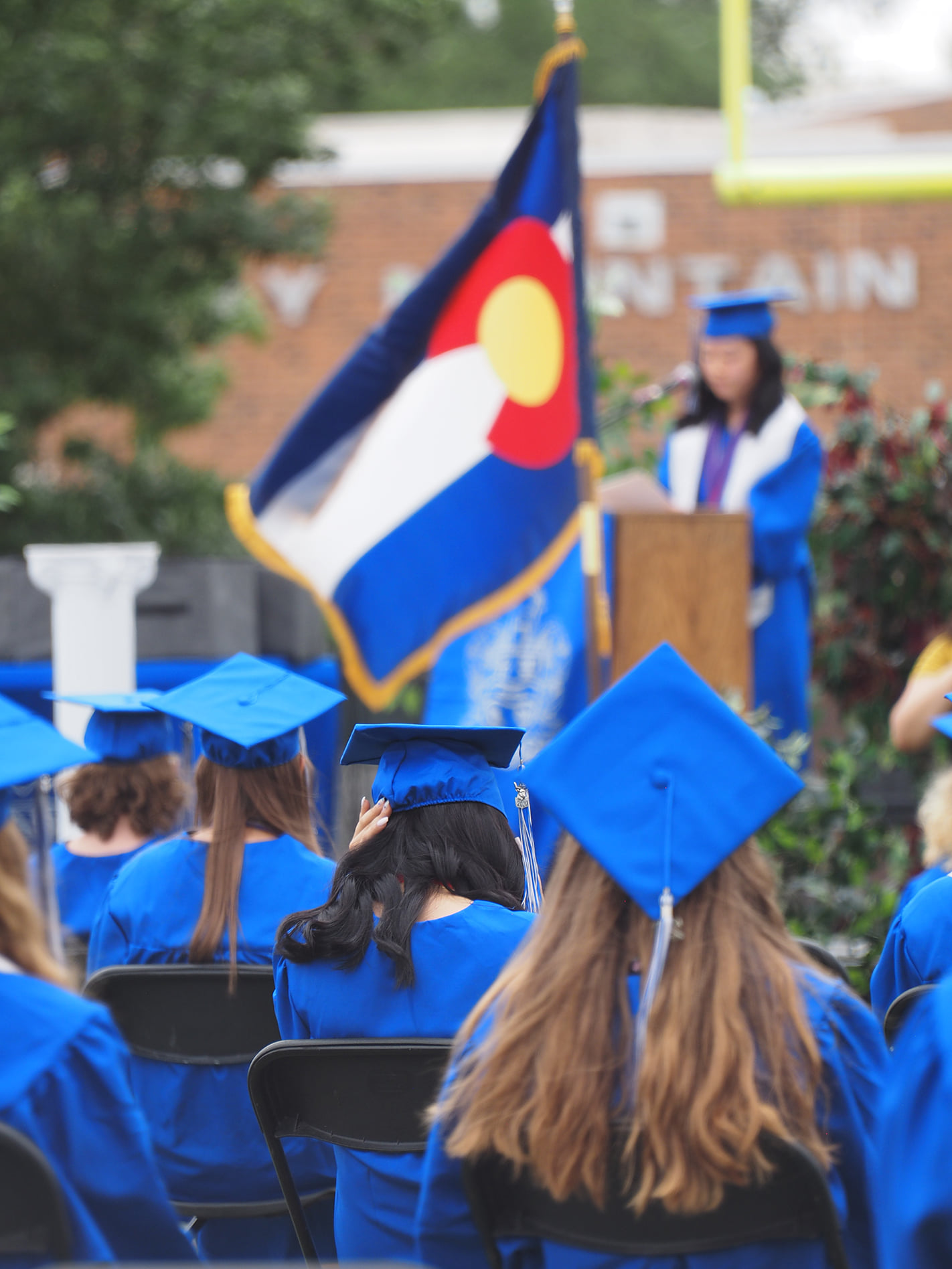 PHS grads with the Colorado flag in the background.