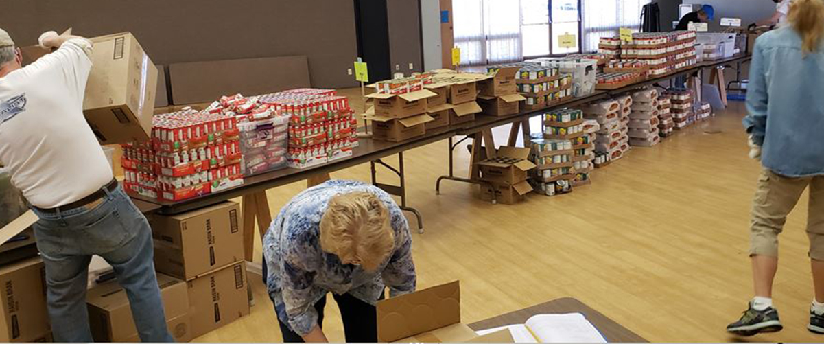 Volunteers sort food for McKinney Vento backpacks for students.