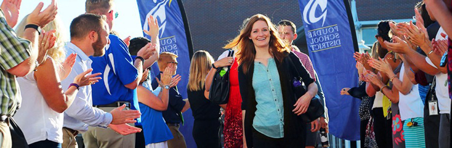 New educators are welcomed at orientation while walking down a red carpet.