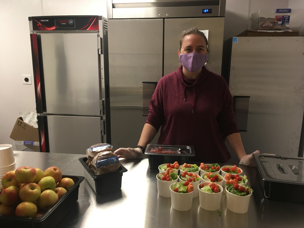 Child nutrition staff member shows off salads at Livermore Elementary