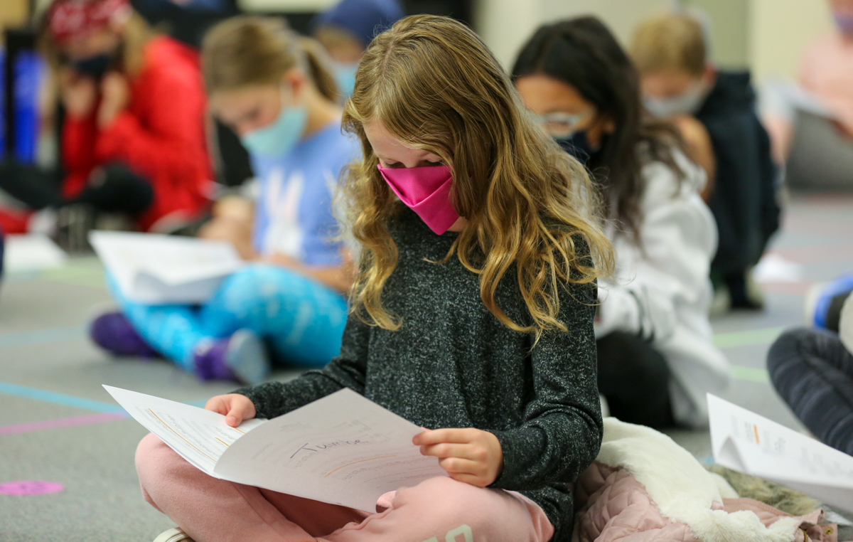 An elementary student looks at her music.