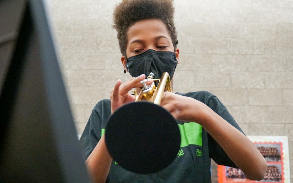 A middle school student plays the trombone.