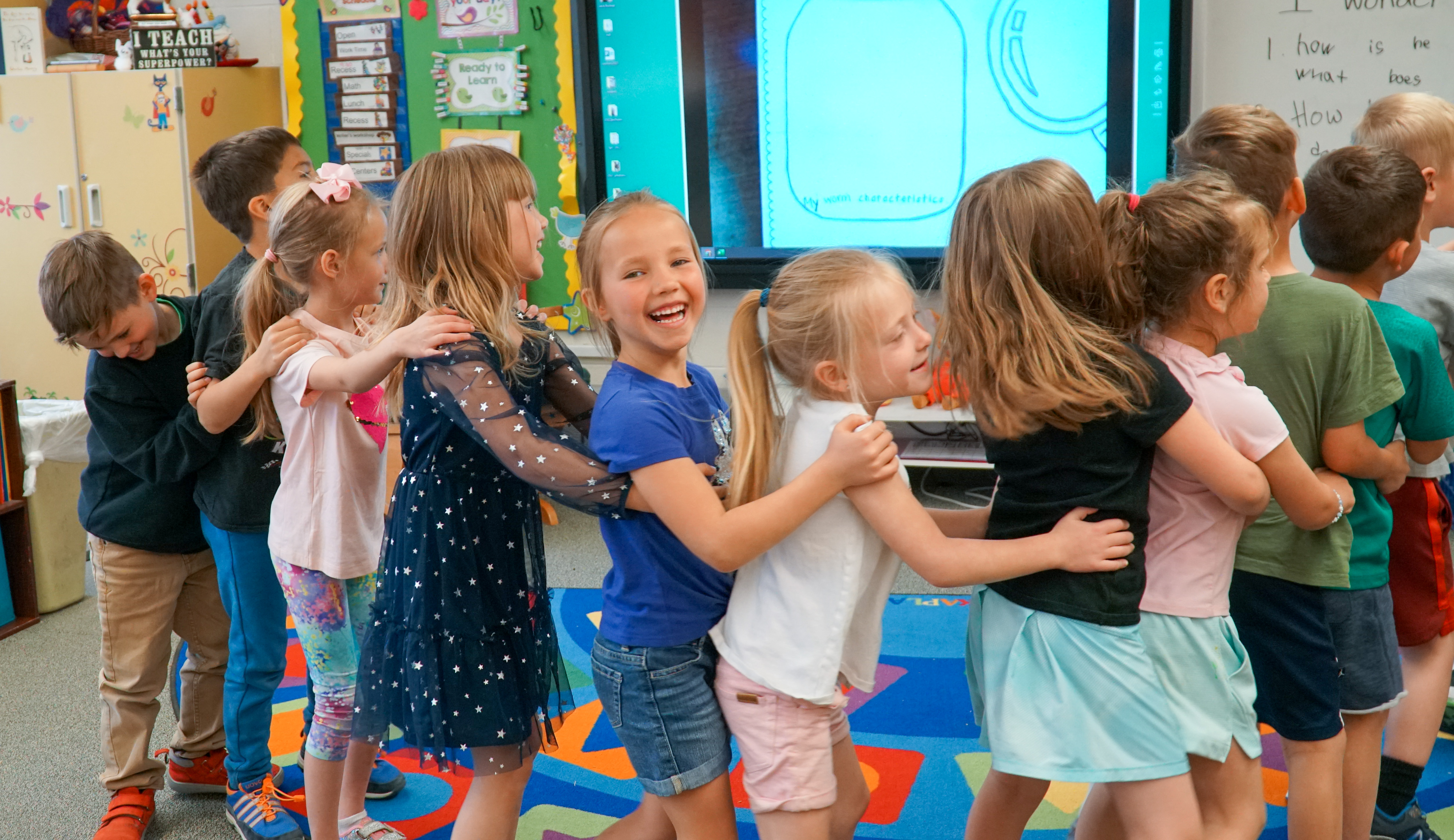 Kindergarteners in a line pretending to be a worm. 