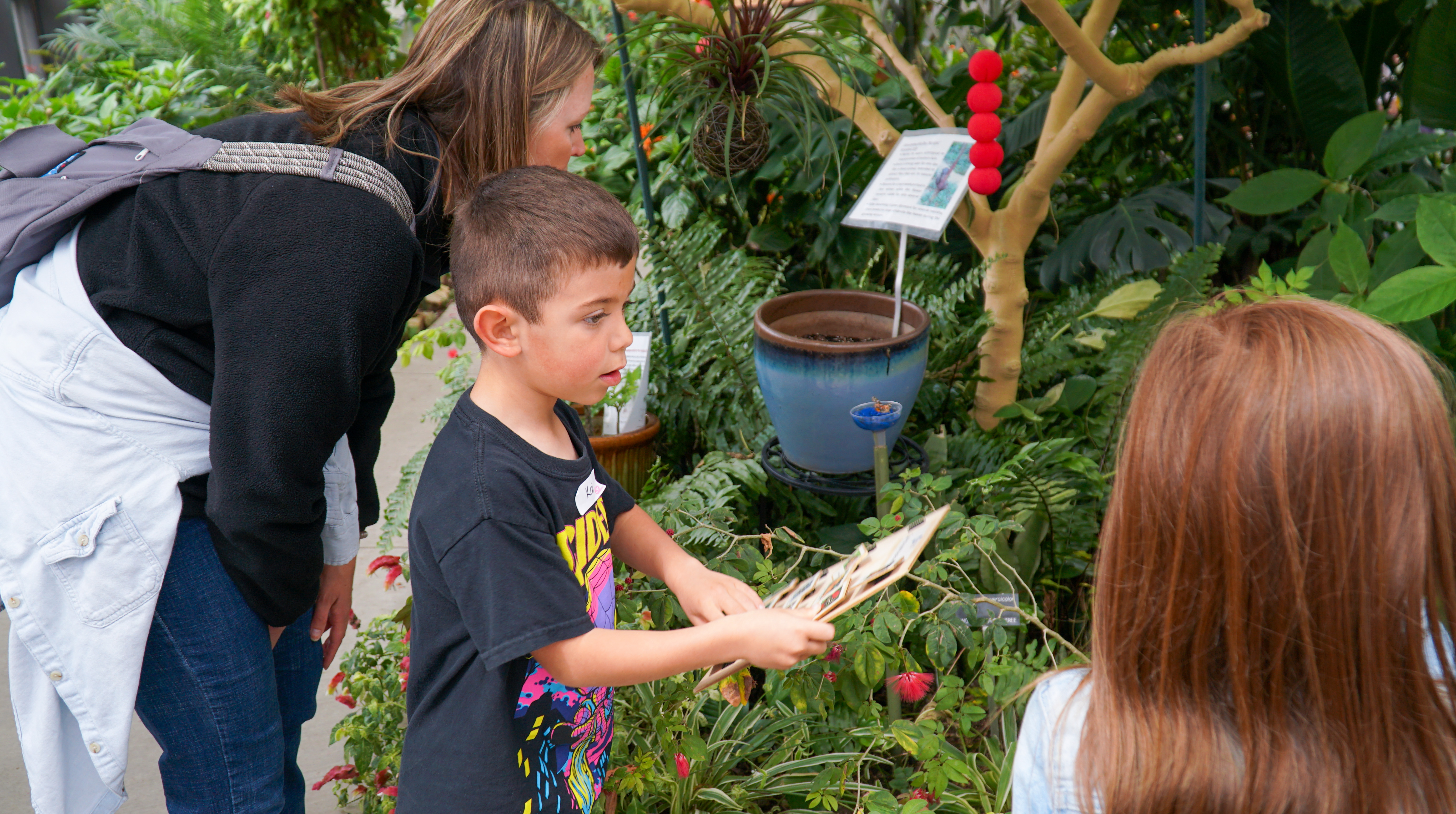 A kindergartener makes notes on his paper at the Butterfly House