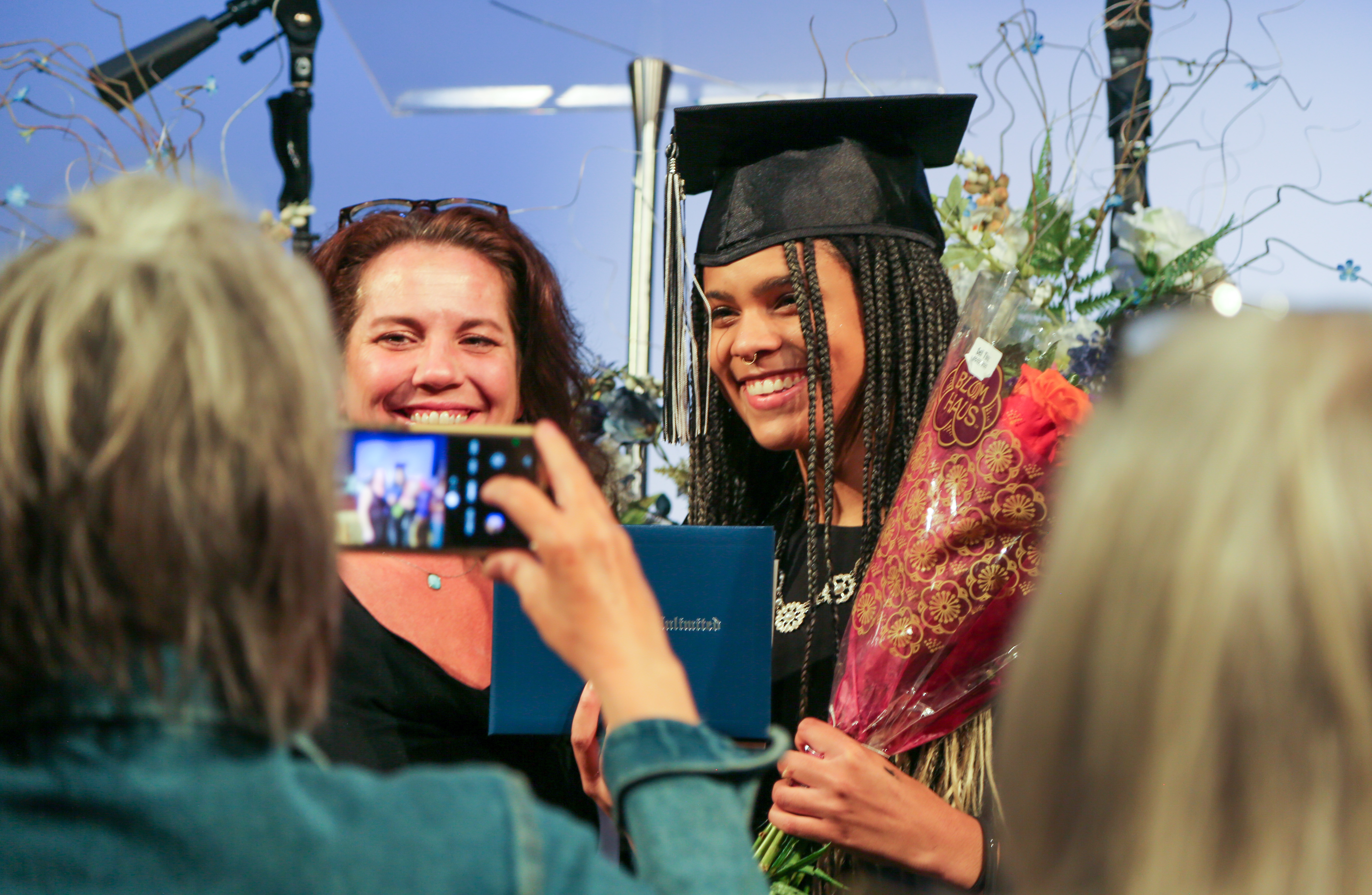 An OU graduate smiles while getting her photo taken. 