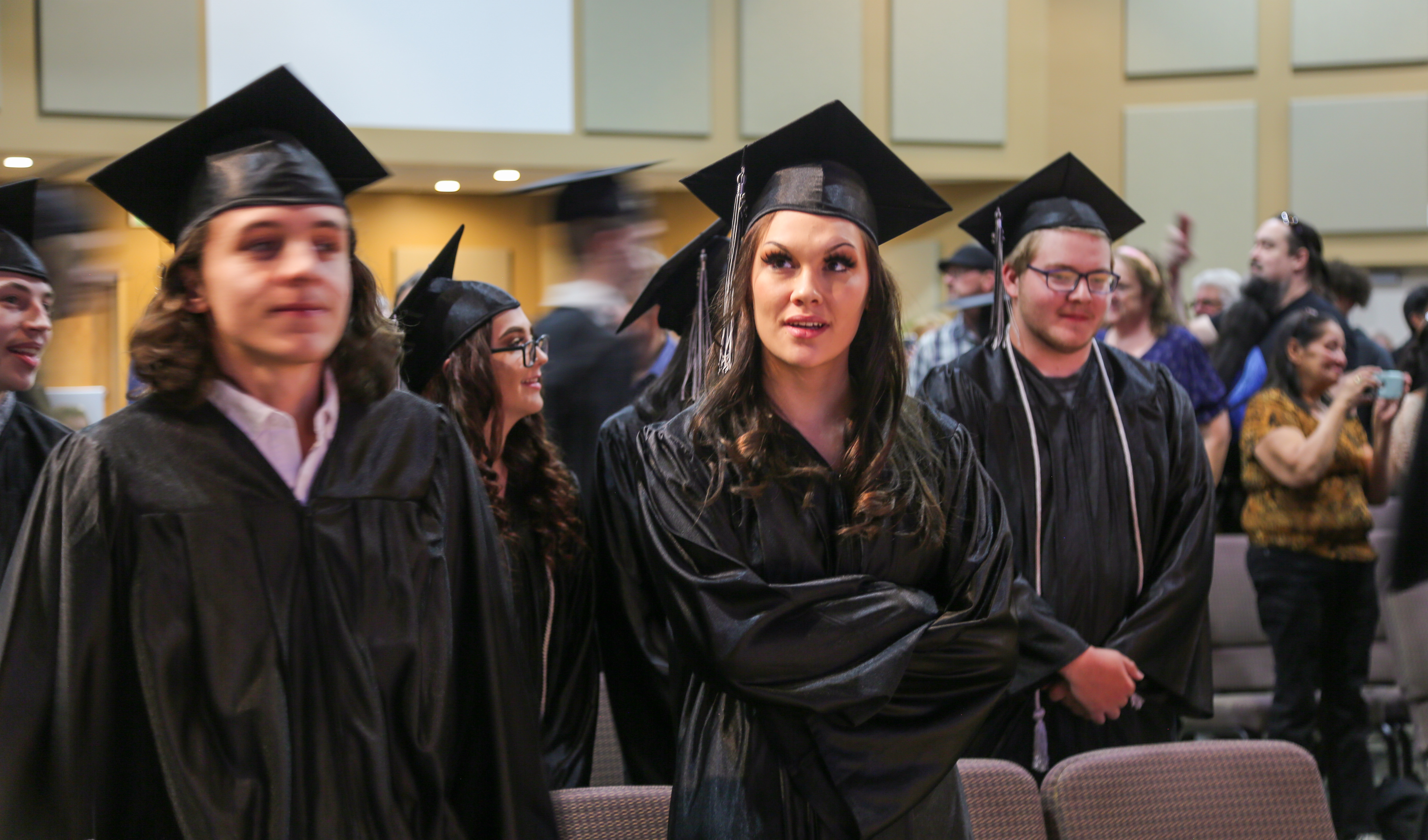 A group of OU graduates smile in the audience. 