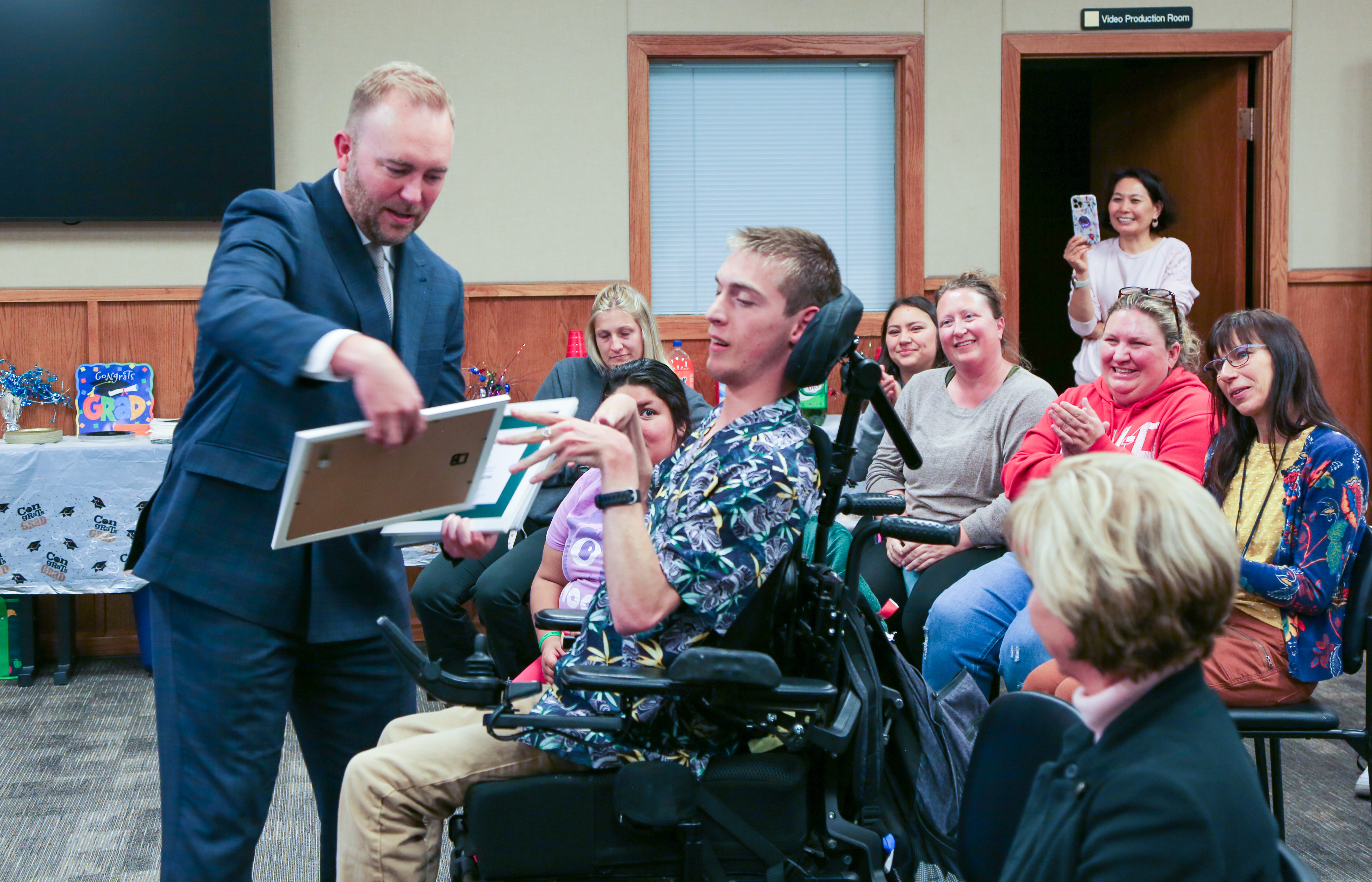 The superintendent presents a certificate to the Community Connections graduate. 