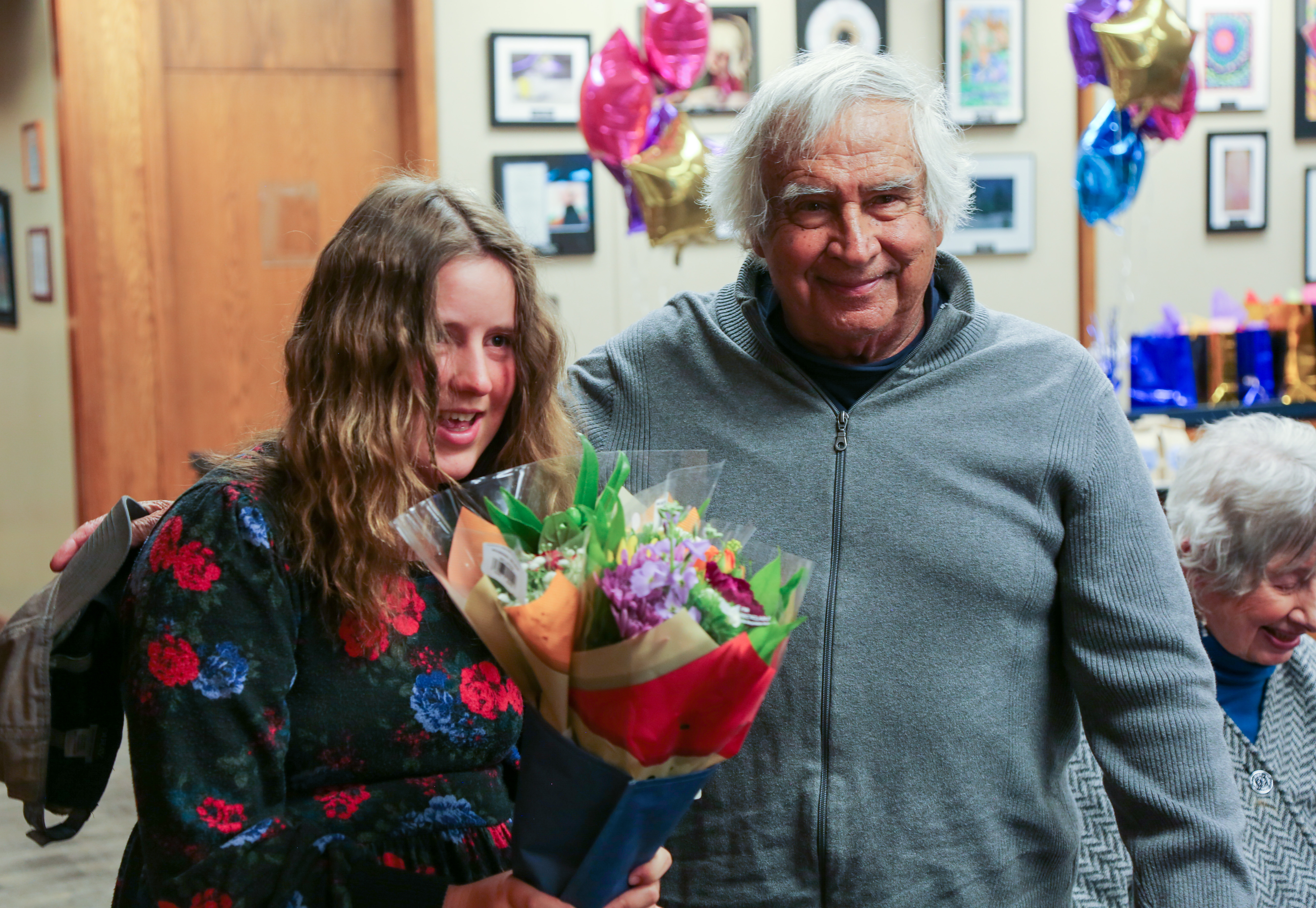 A young woman holds flowers at the Community Connections celebration. 