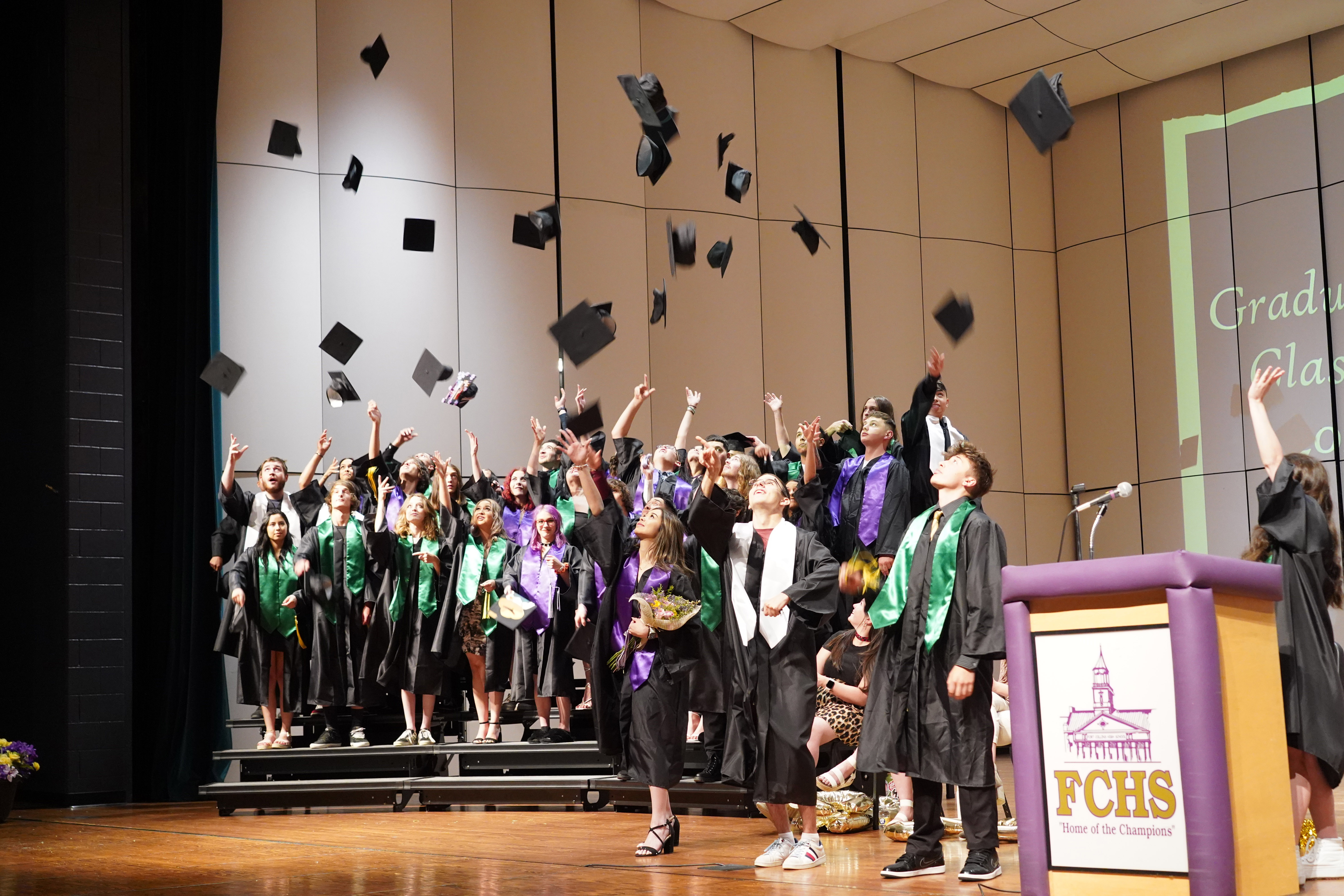 OU south program graduates throw caps in the air.