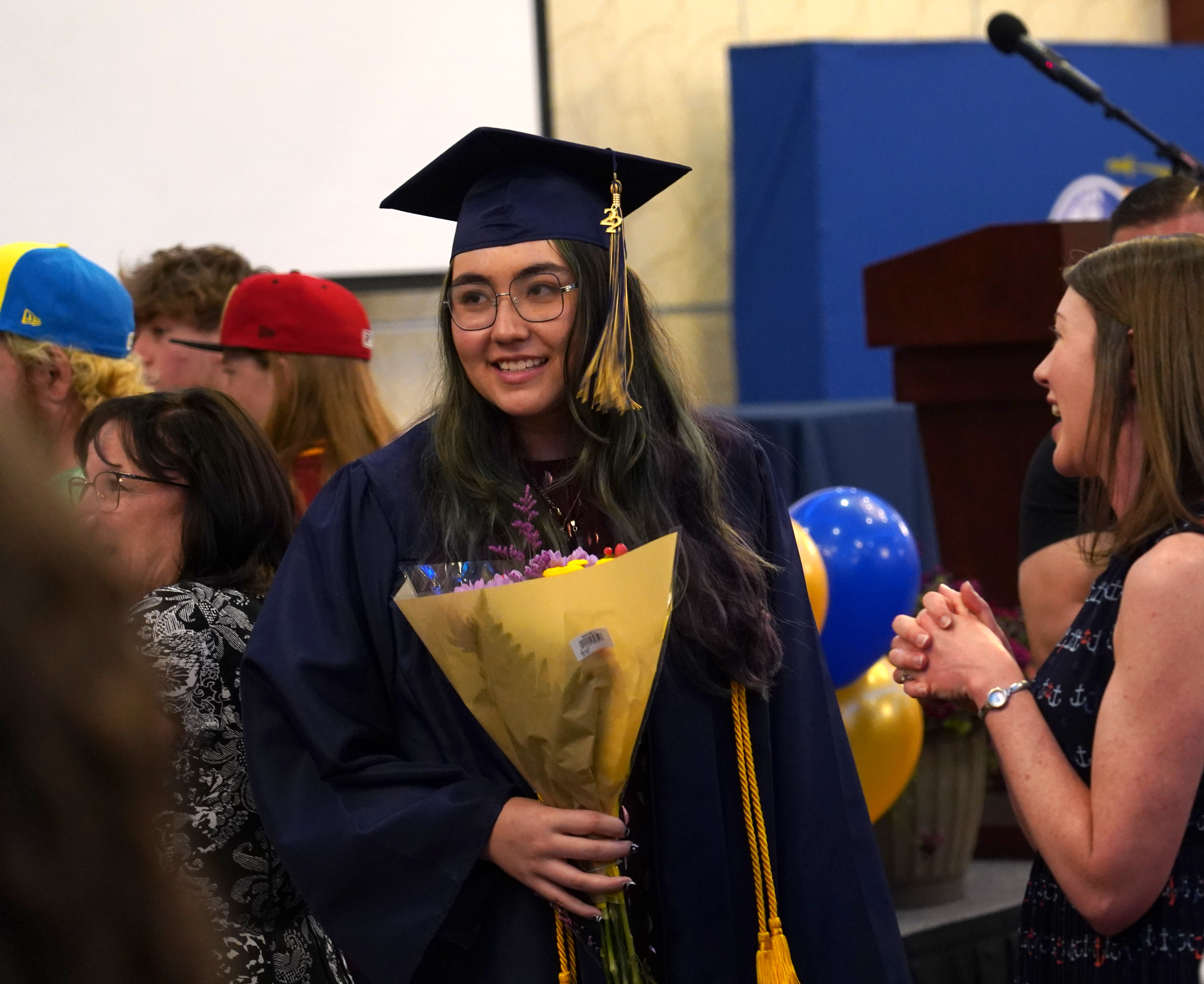 PGA graduate holds flowers and smiles.