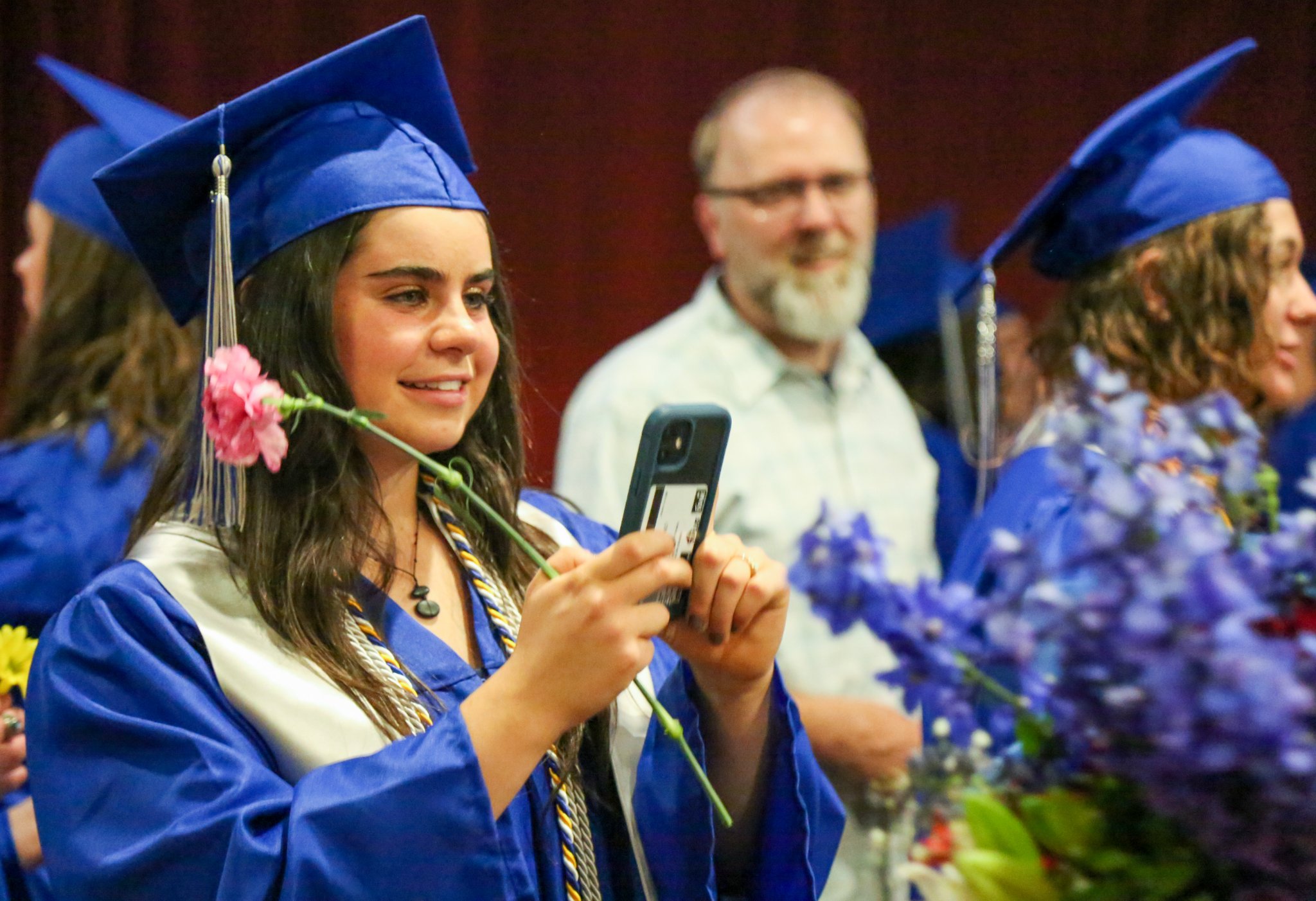 A PHS IB graduate takes photos during convocation.