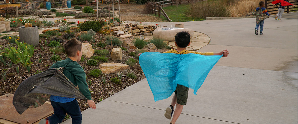 Kindergarten students run with butterfly wings.