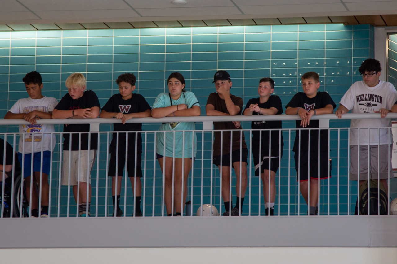 Middle school students stand in the loft overlooking the common space at Wellington Middle High School.