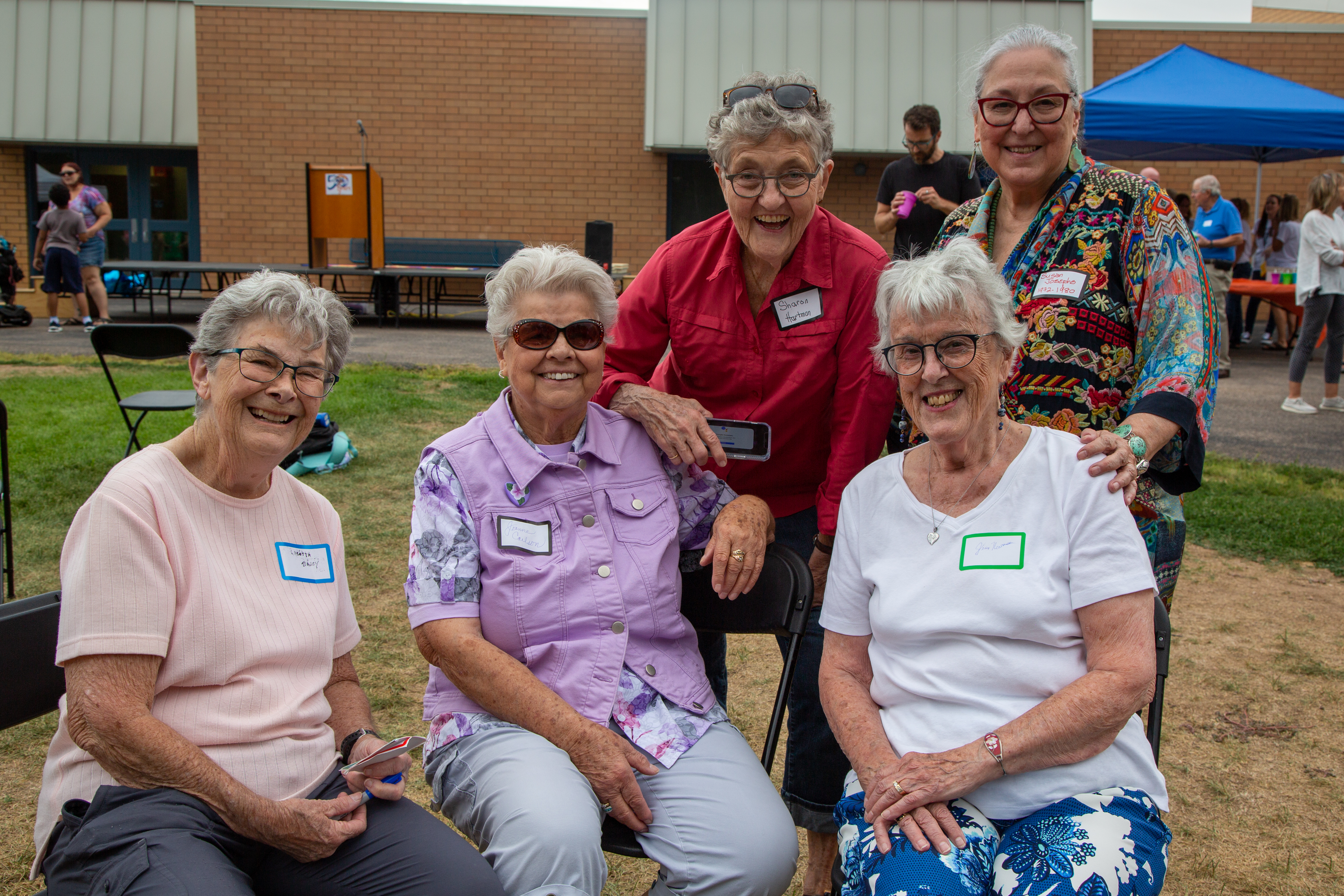 A group of women pose for the camera outside the school. 