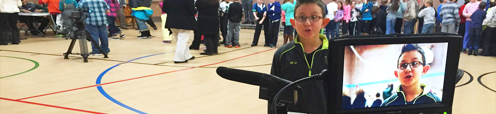 A young student is interviewed in a school gym. 