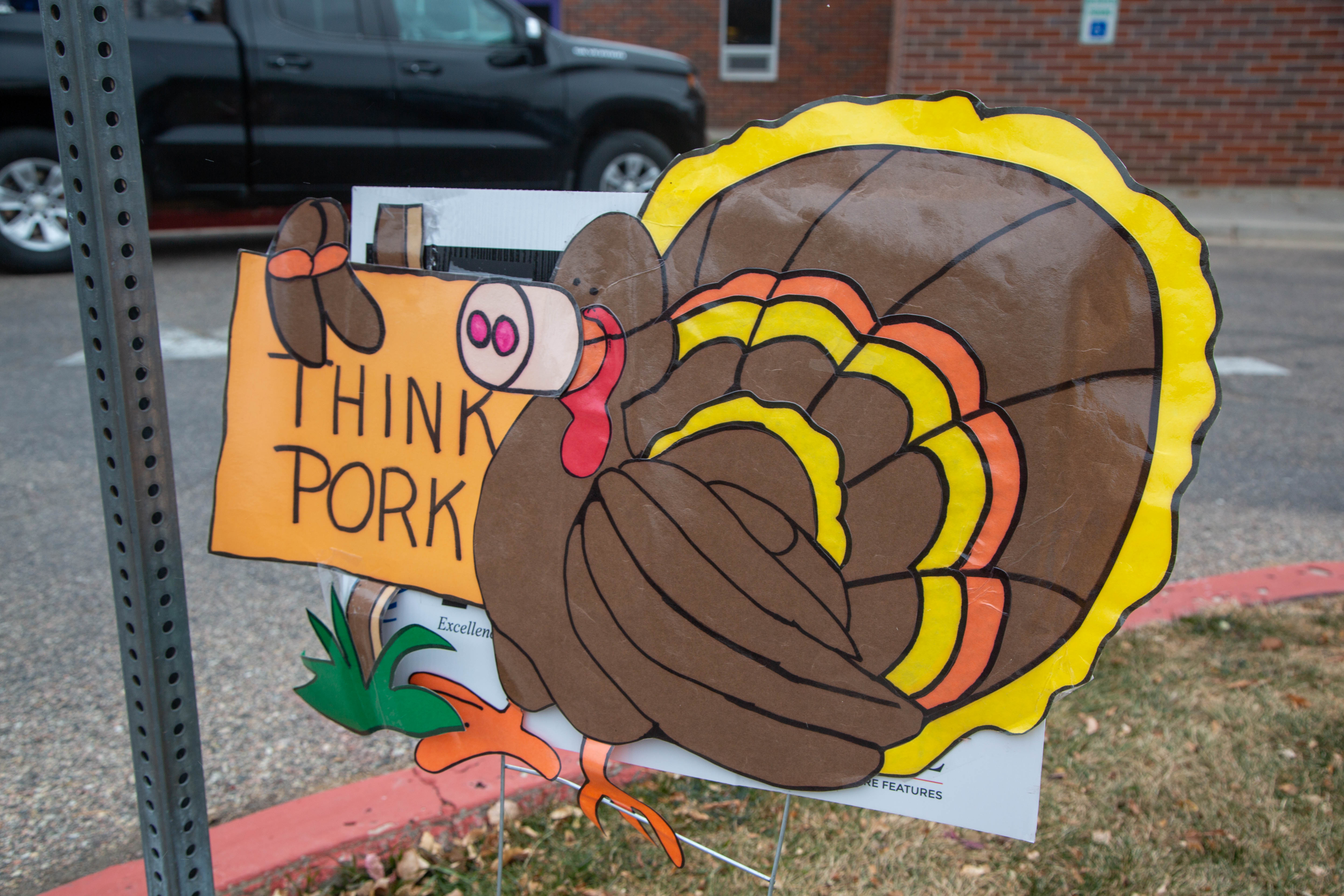 A picture of a turkey with "Think Pork" sign by its side. 