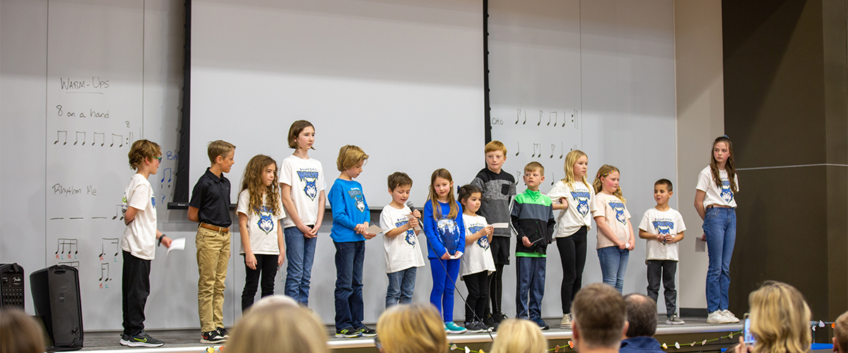 Bamford Elementary students talk on stage at the pantry opening. 