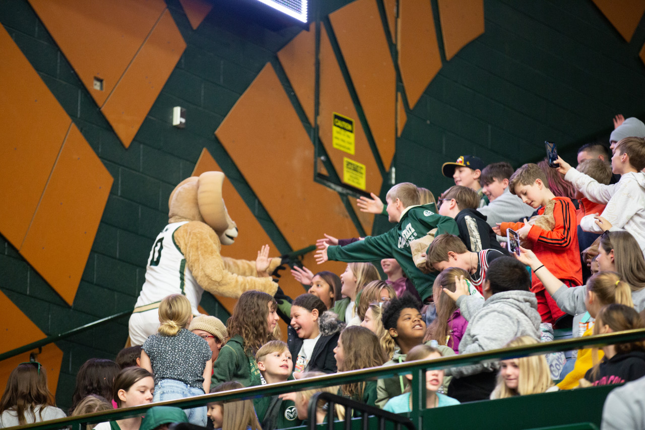 Cam the Ram with students at the basketball game. 