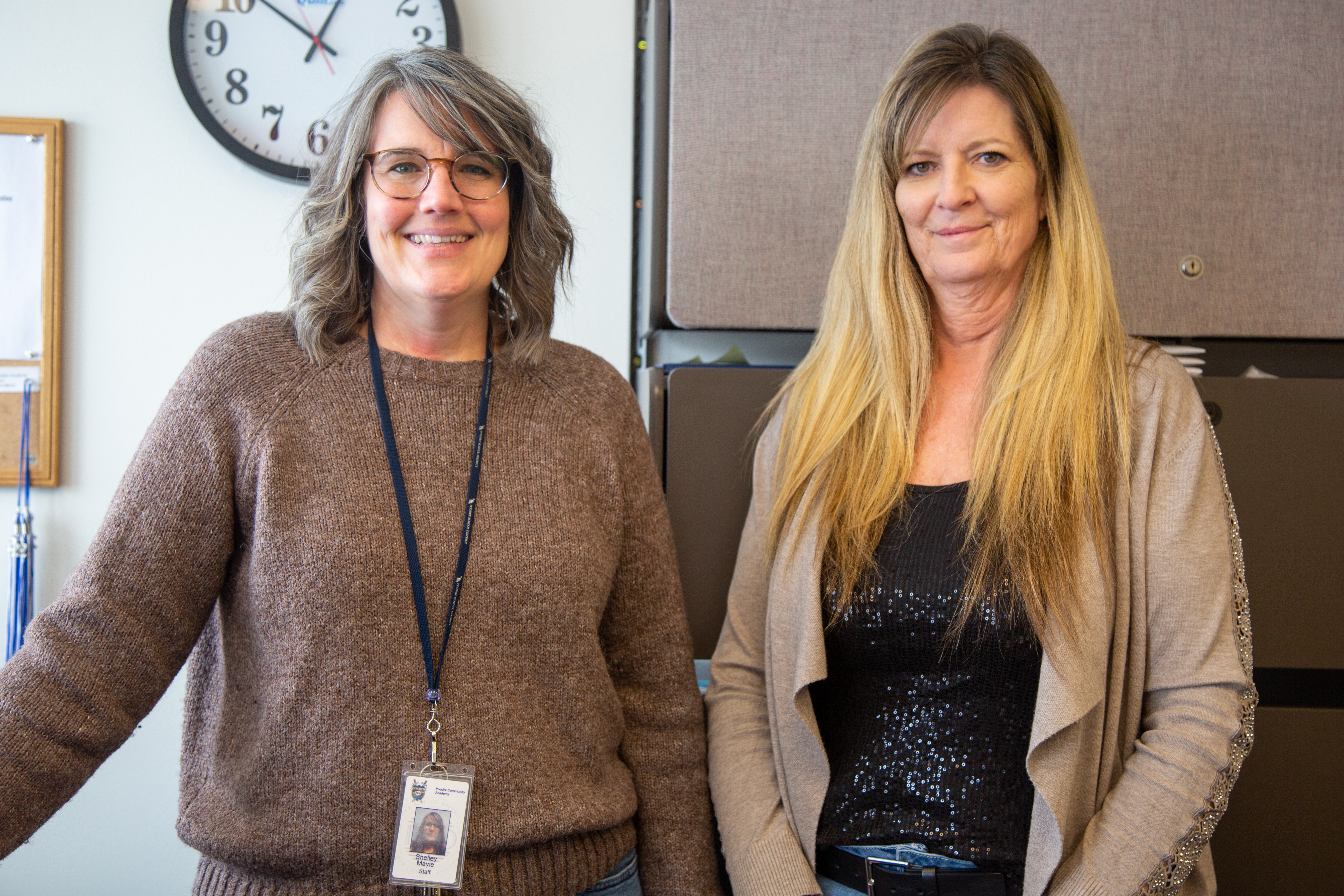 Two classified staff members at Poudre Community Academy stand together. 