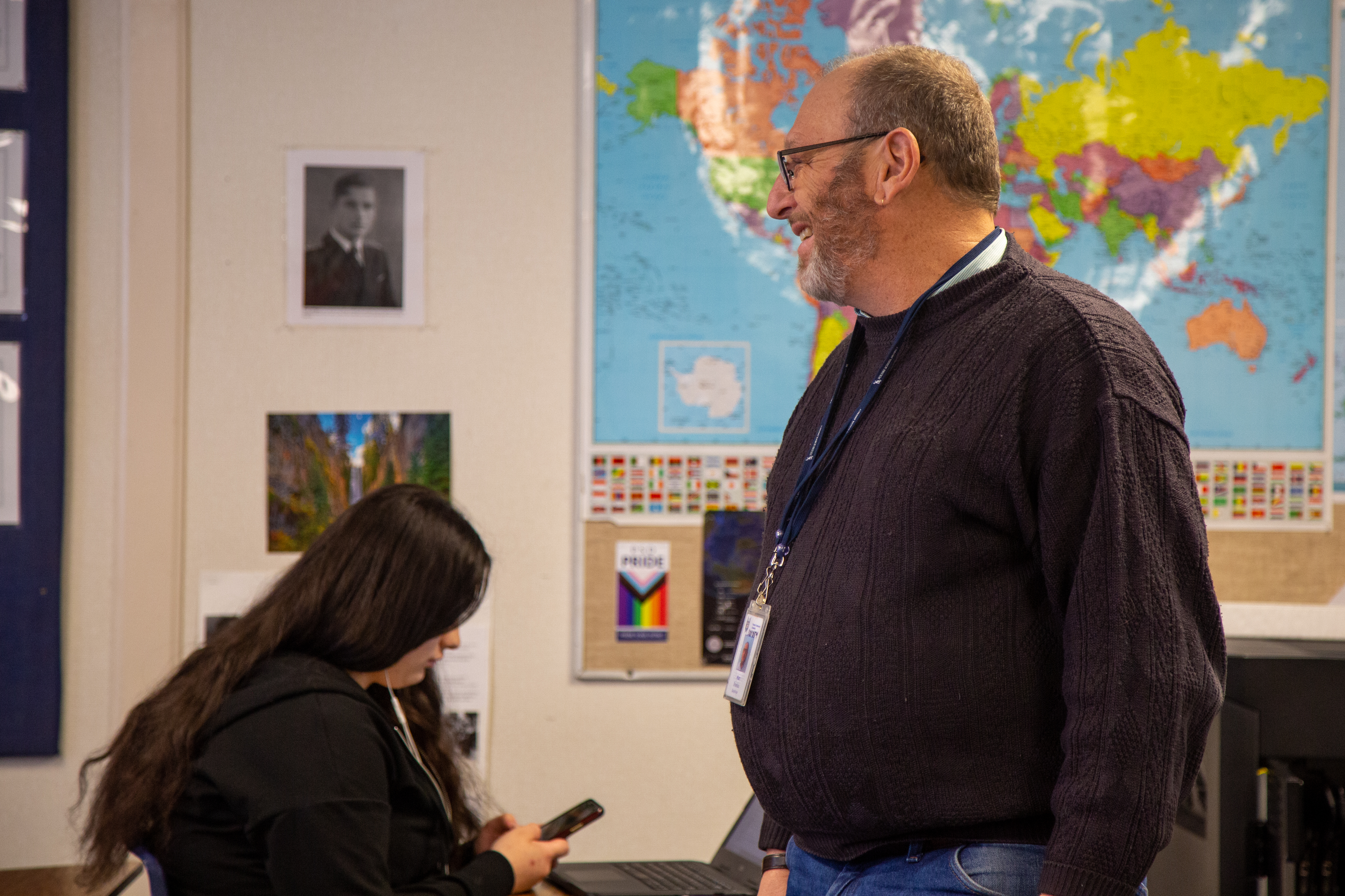 A classified staff member smiles at a student at Poudre Community Academy. 