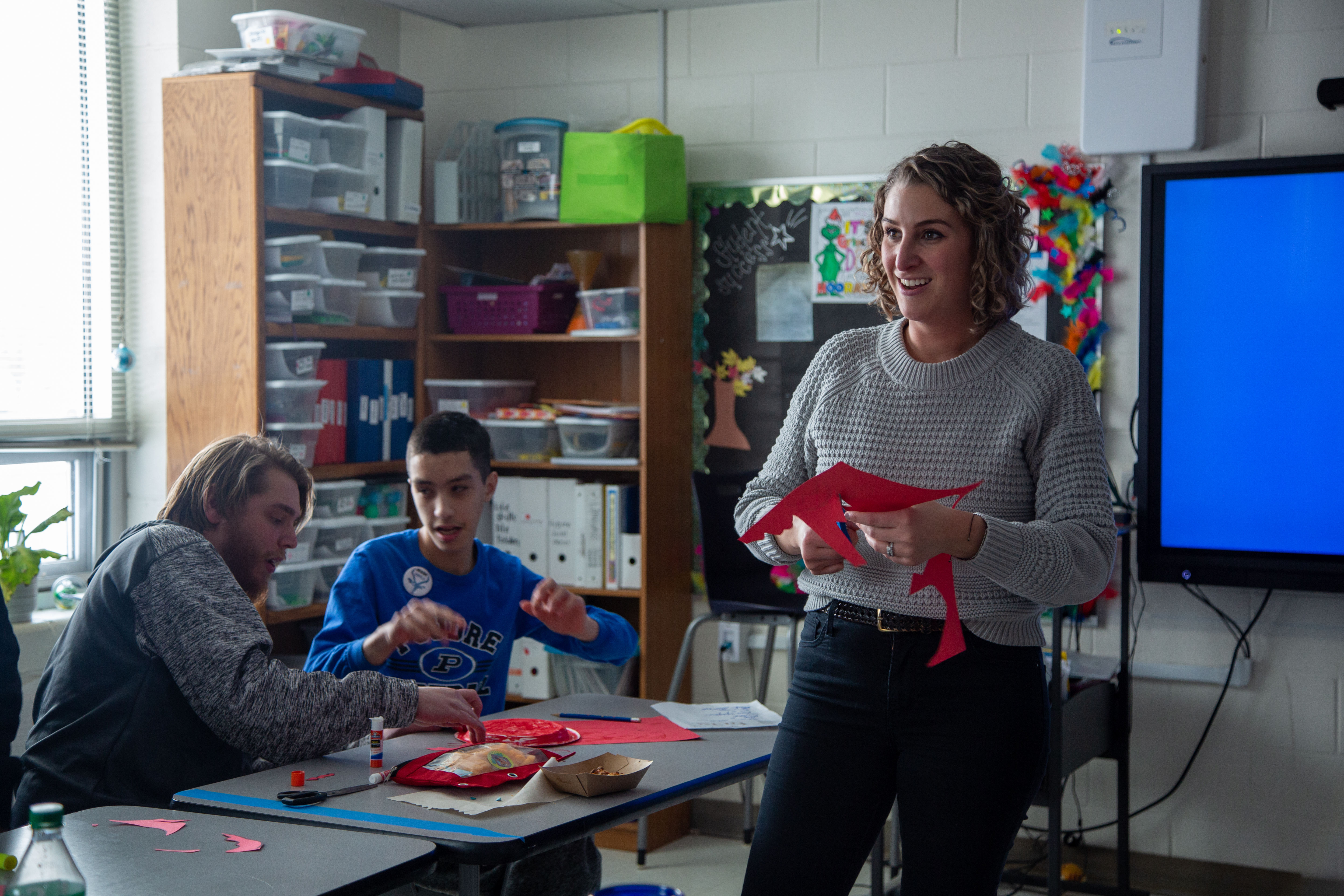 Two classified staff members work with students at Poudre High School. 