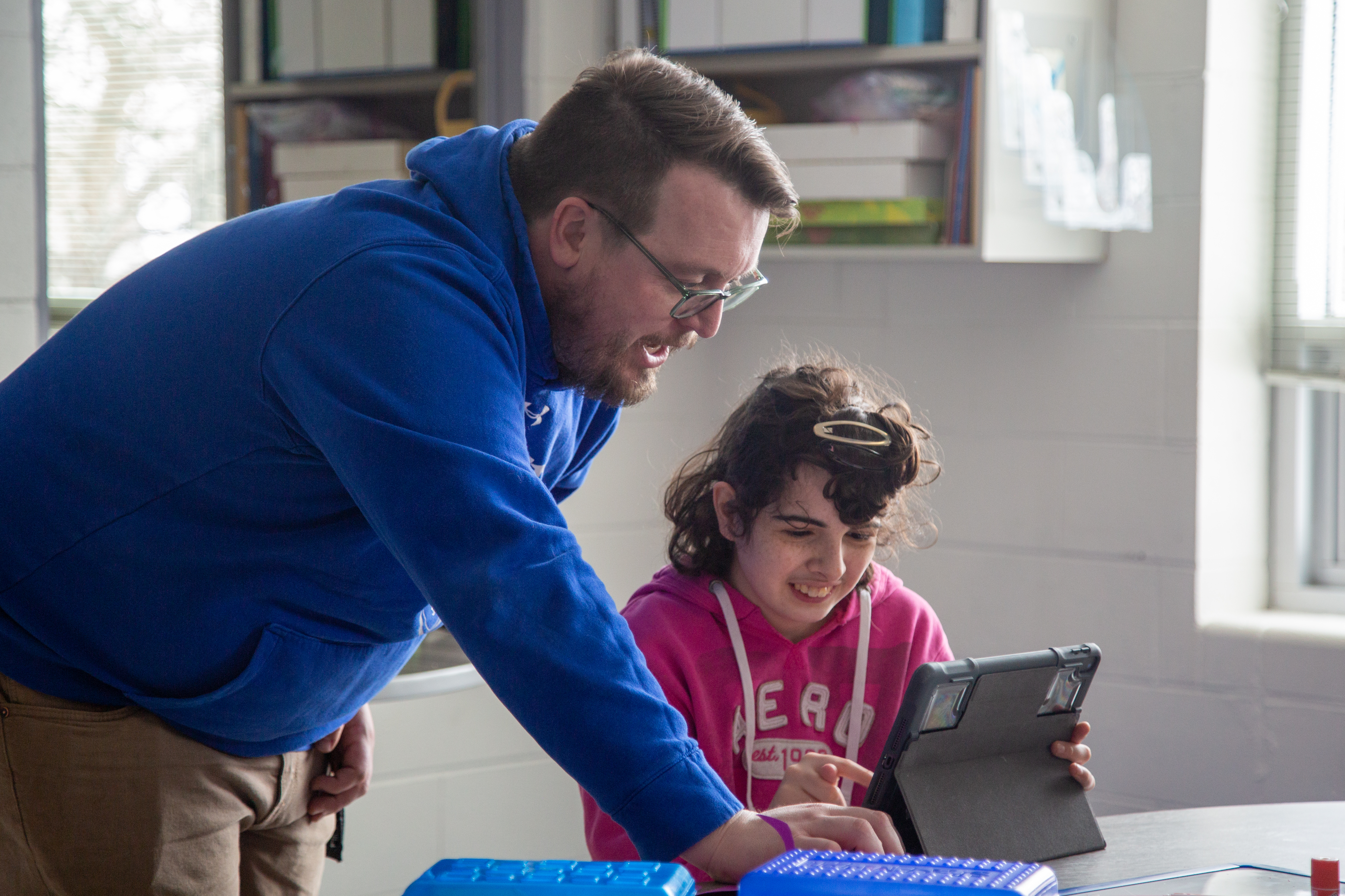 A Poudre High School staff member works with a student. 