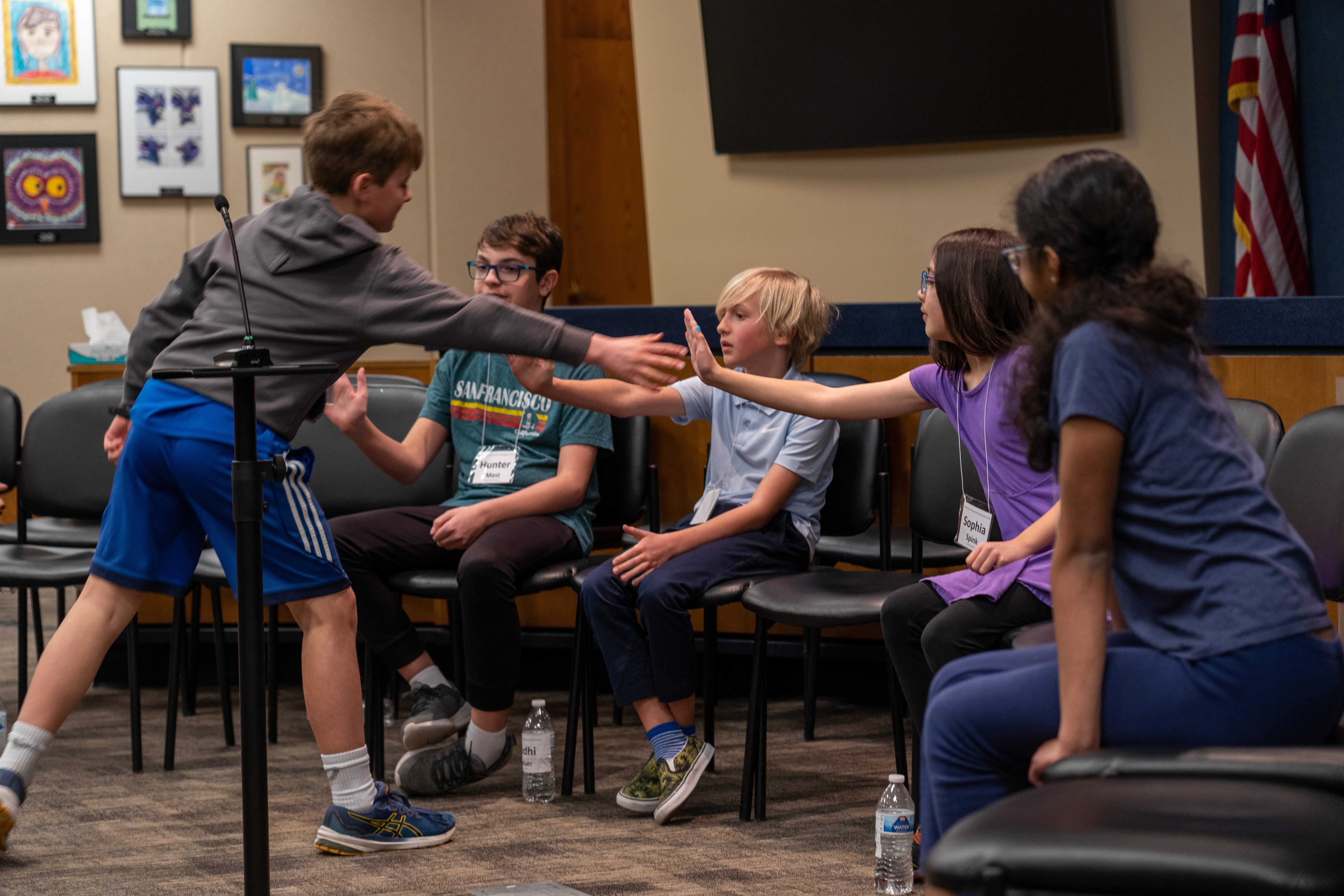 Spelling bee participants encourage each other with high fives.