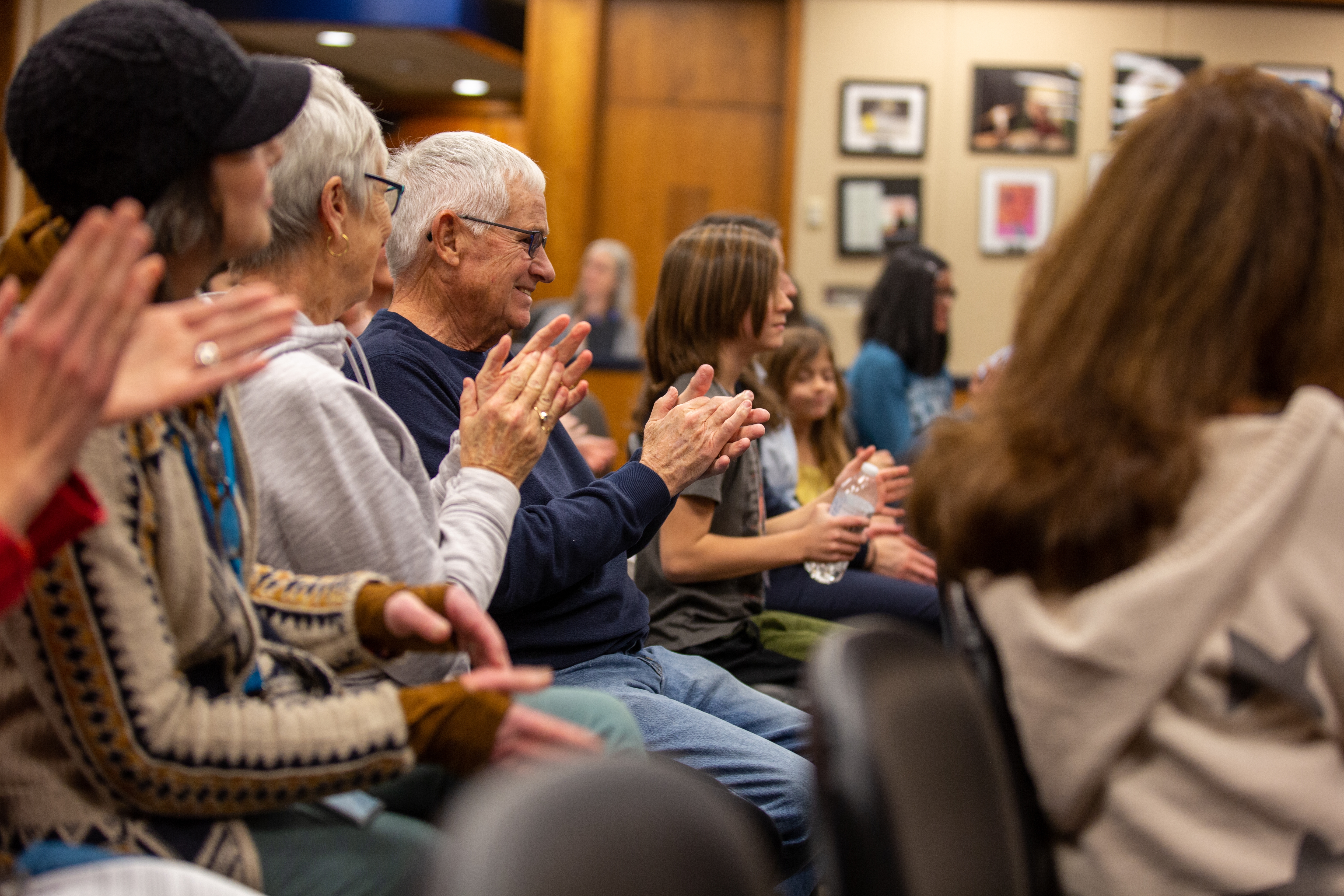 Audience members clap for the spelling bee participants. 