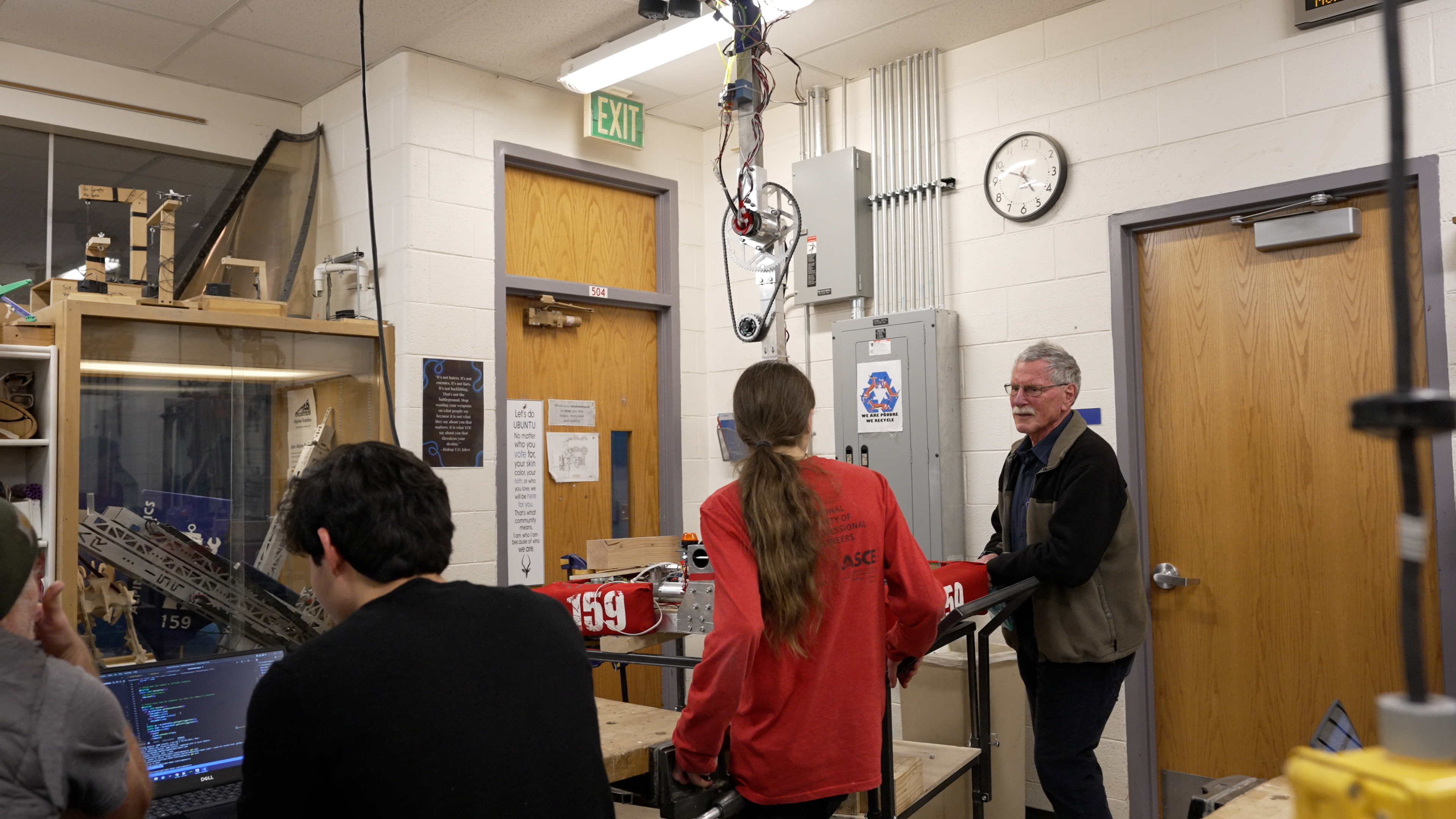 A Poudre High School volunteer works with students in the robotics class. 