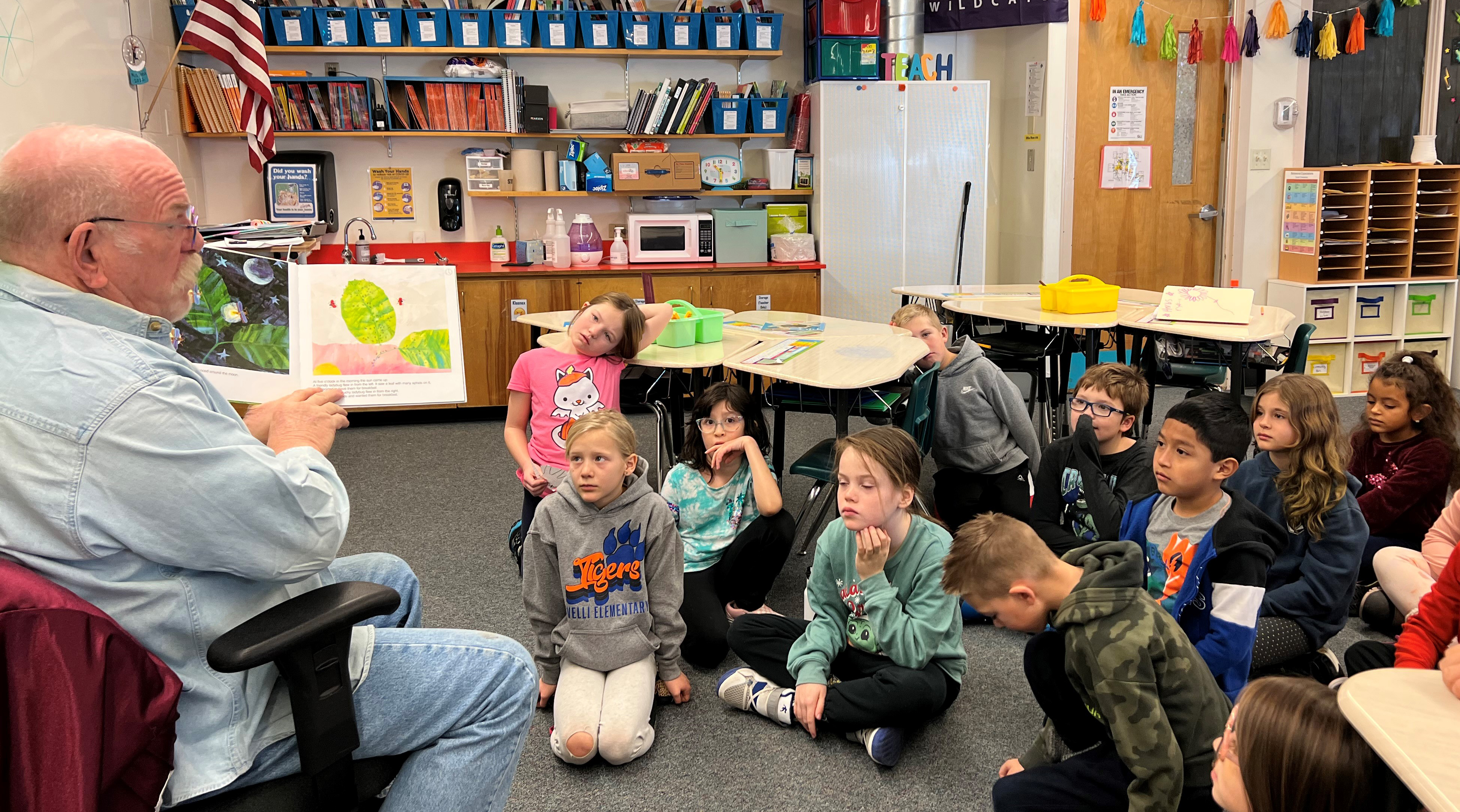 A volunteer reads to Tavelli Elementary students.