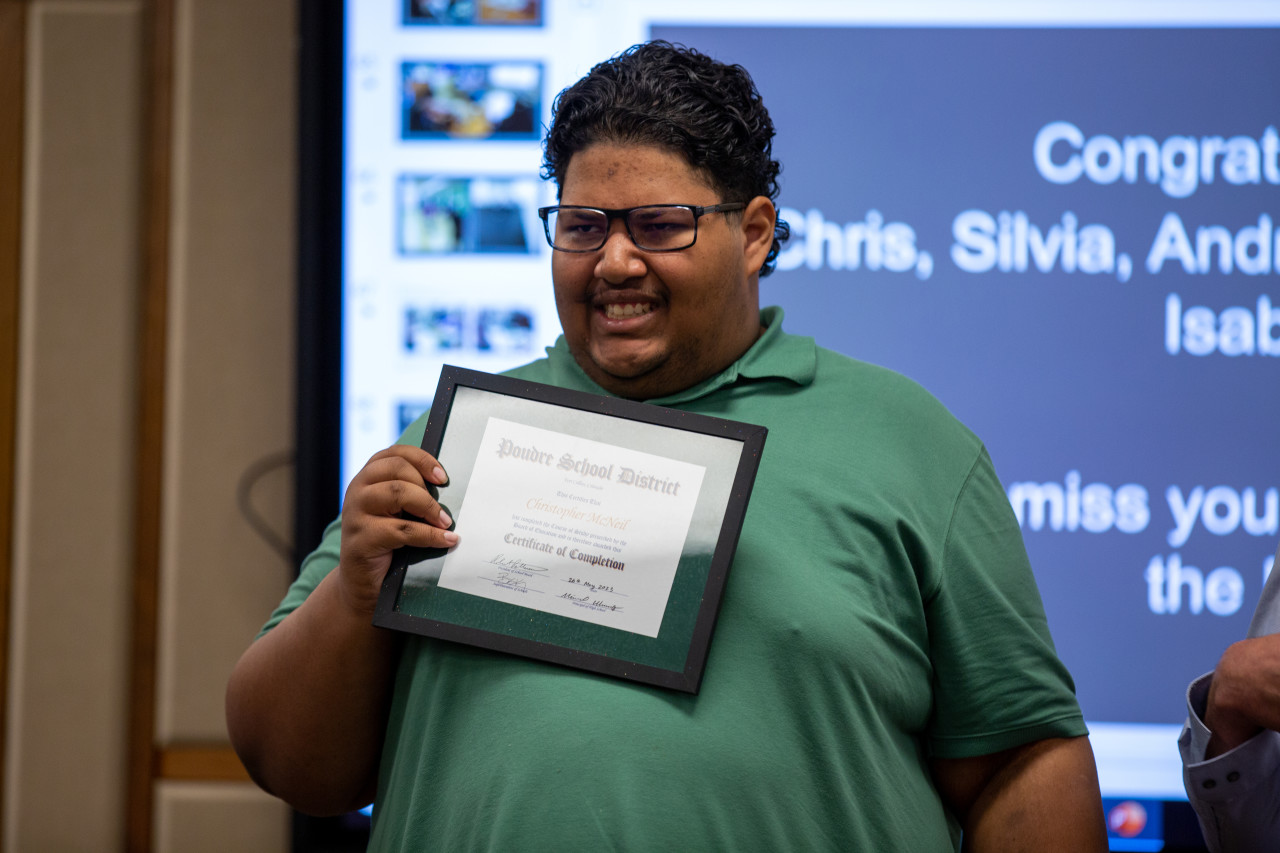 A Community Connections graduate holds his certificate. 