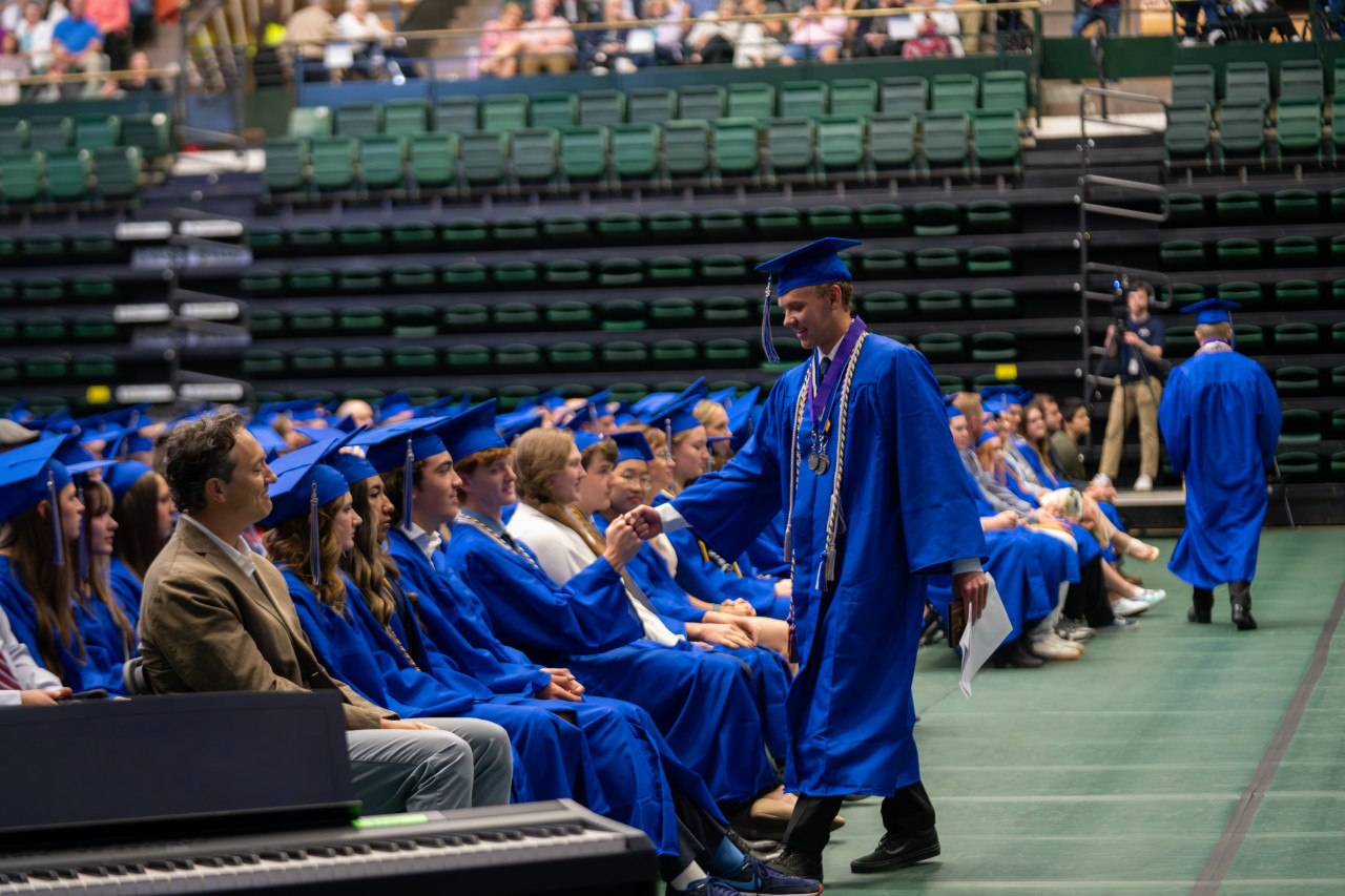 A PHS grad high fives another graduate. 