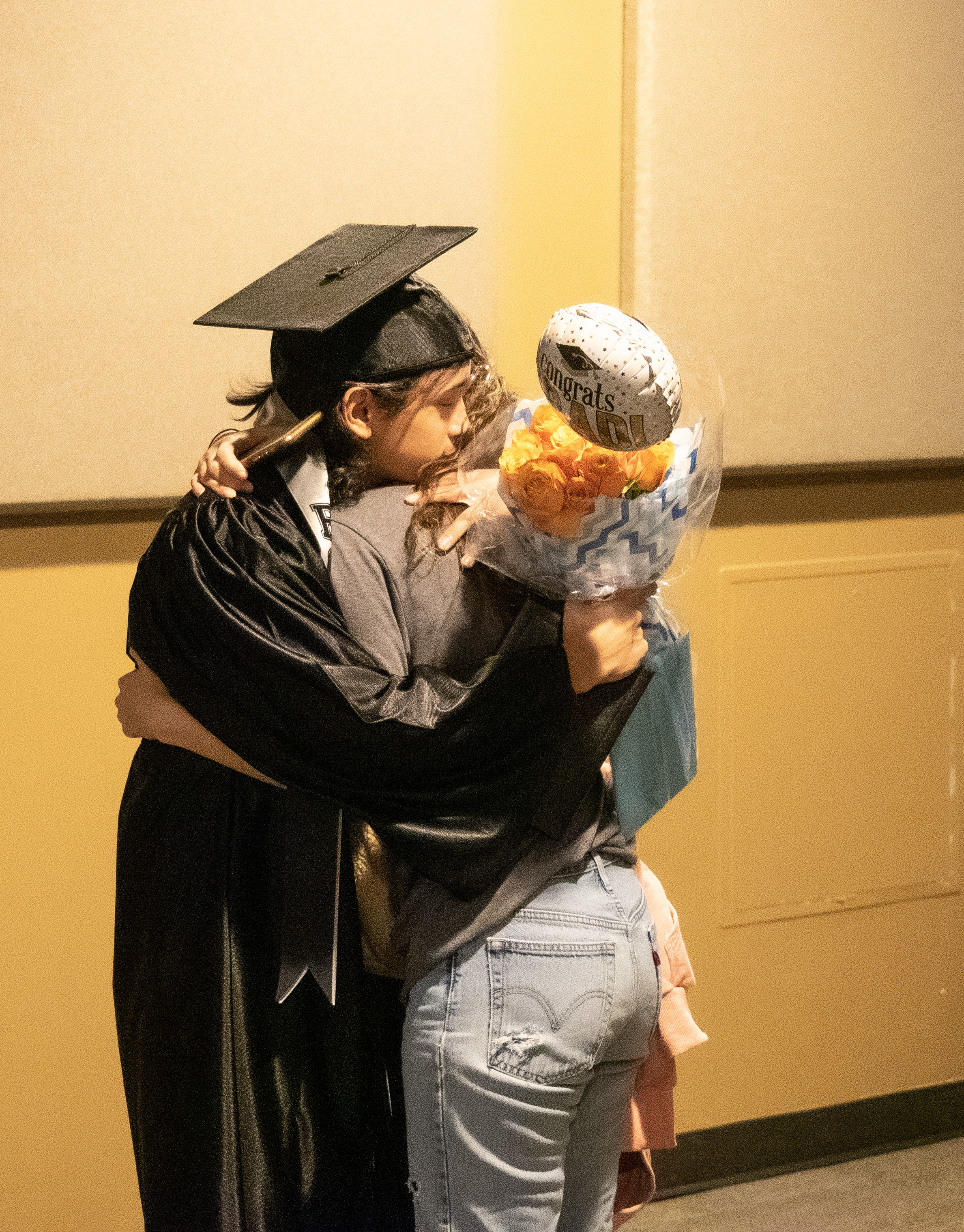 An OU graduate hugs family and friends at the ceremony. 