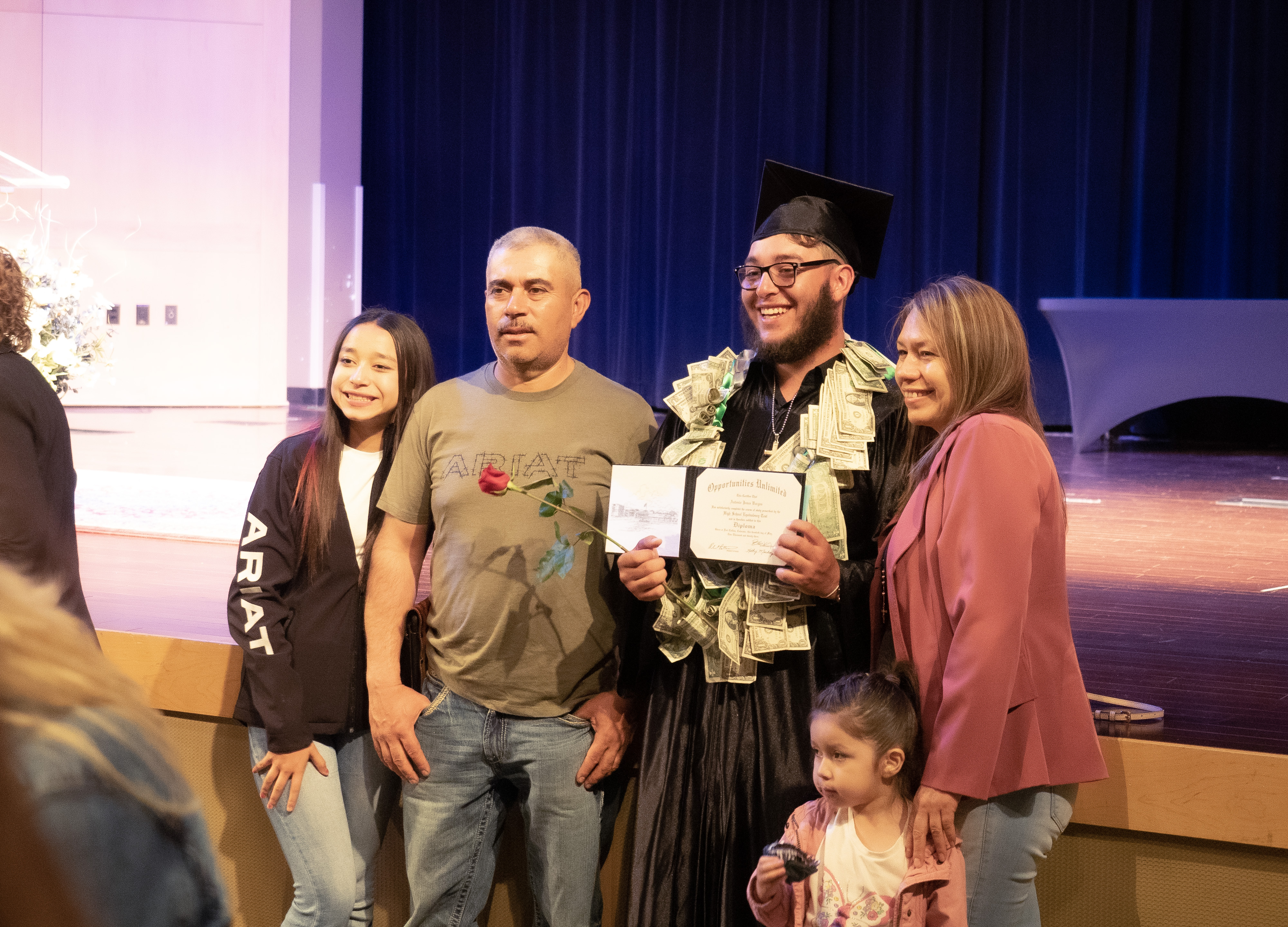 A family poses with a new graduate at the Opportunities Unlimited ceremony. 
