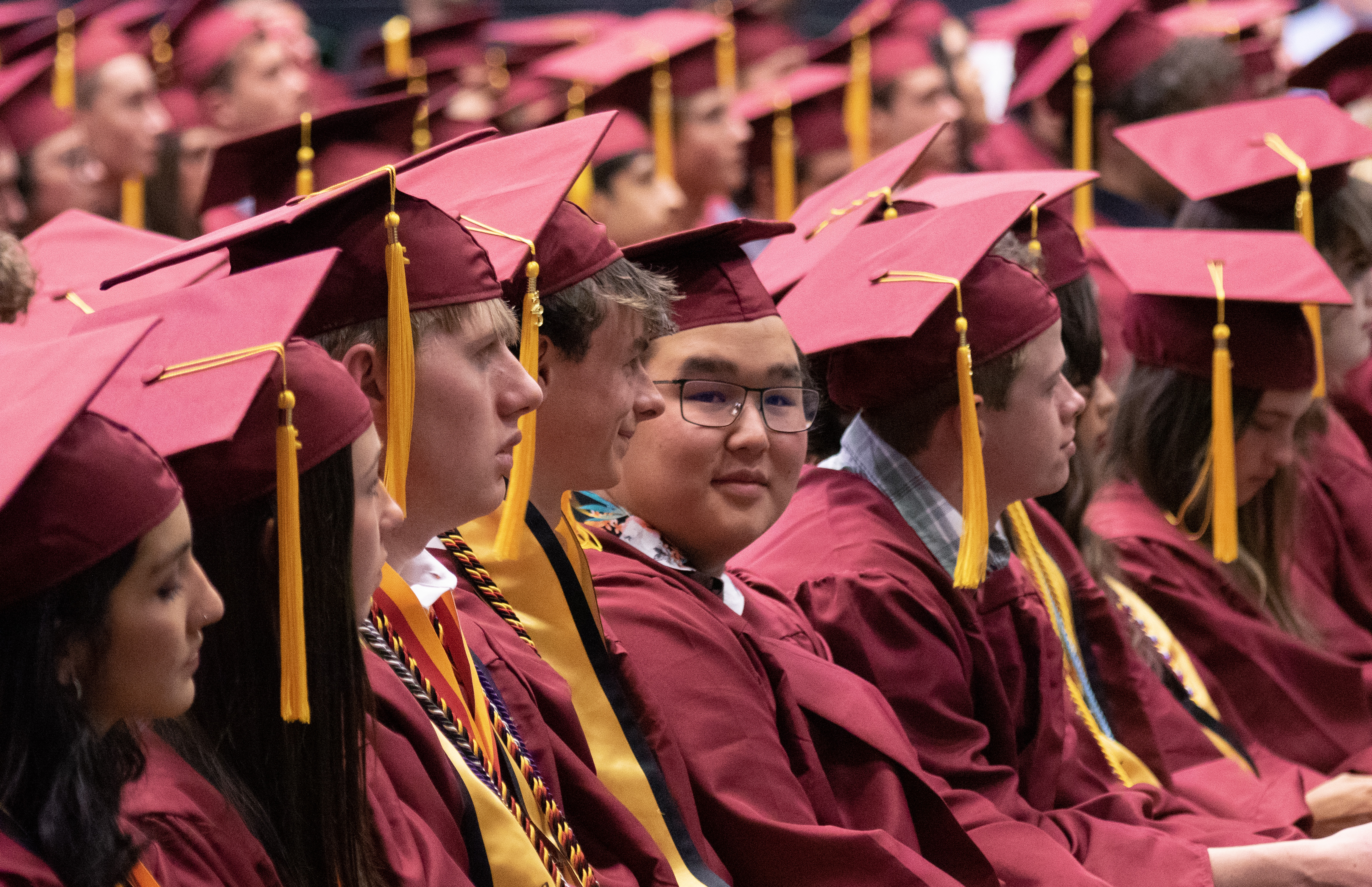 Rocky Mountain High School graduates sitting. 