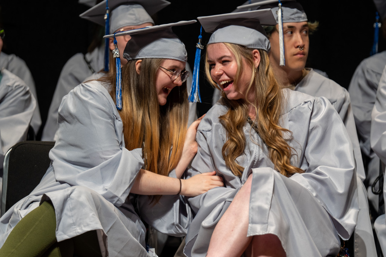 Two Polaris grads laugh together.