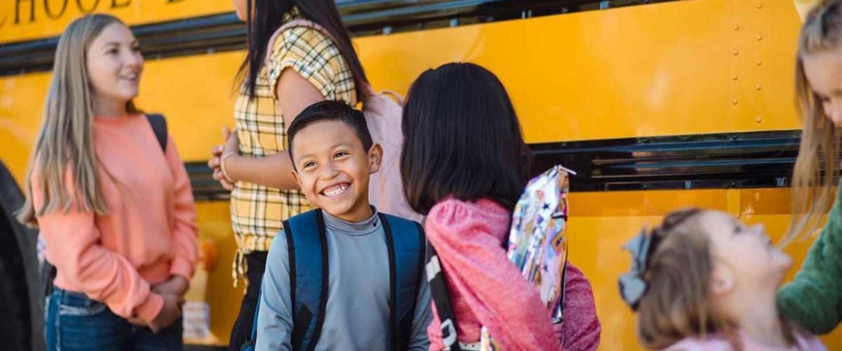 Kids in front of a school bus.