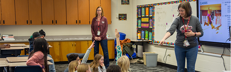 A teacher works with students in class.