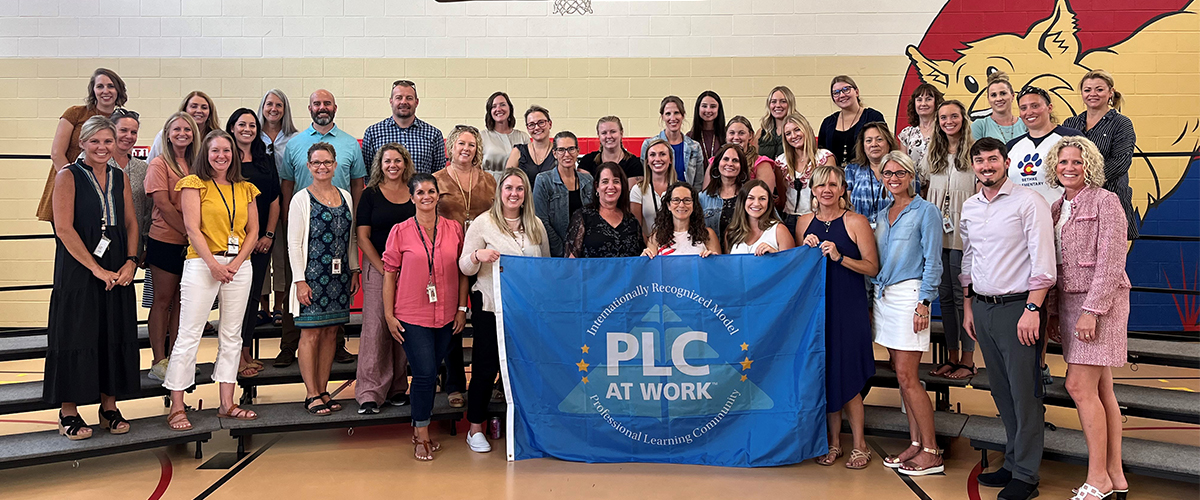 Bethke Elementary staff holding a sign designating their PLC school.