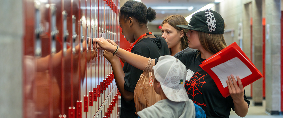 Student leaders help new students open their lockers.