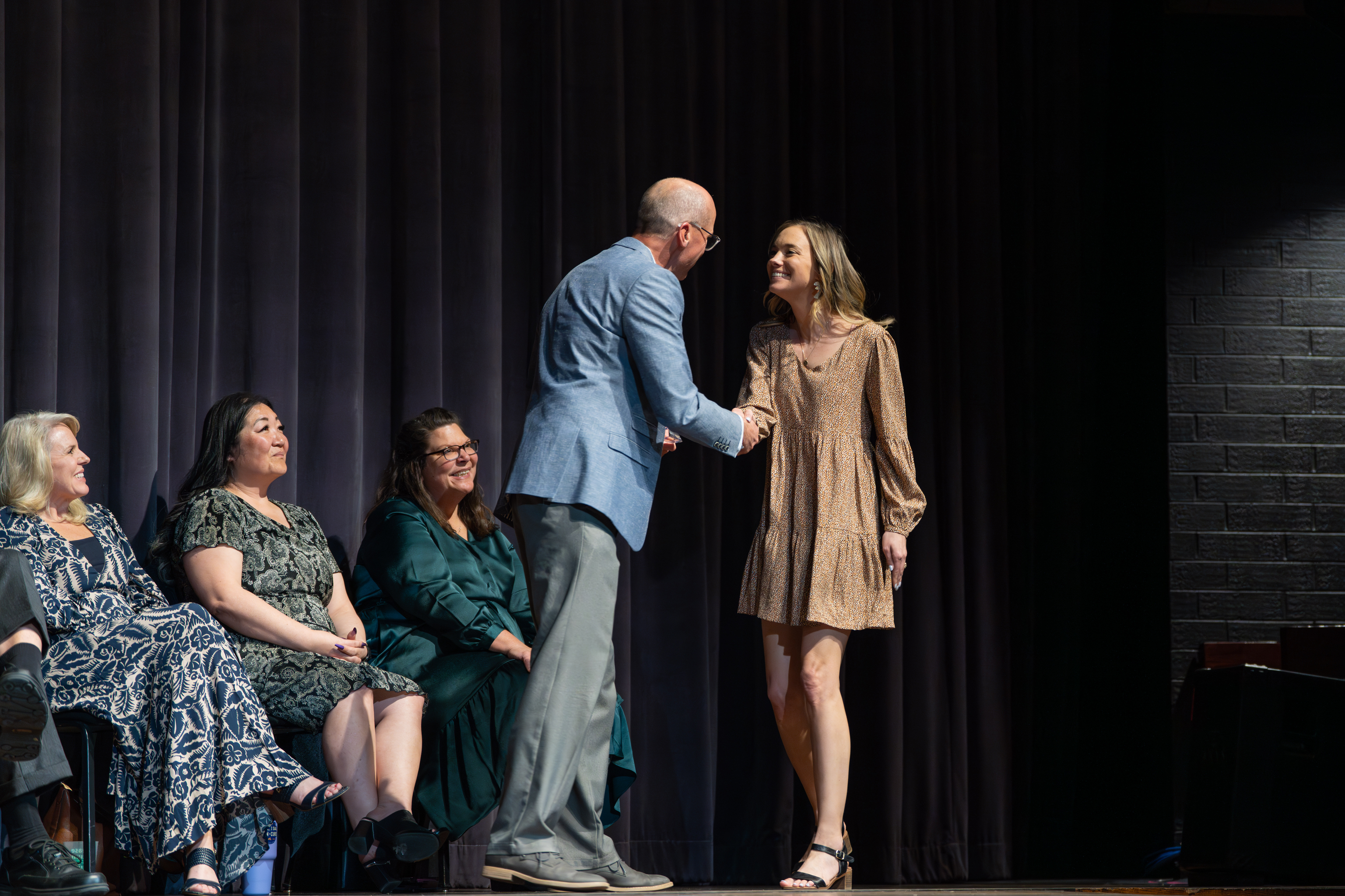 The award winners shakes hands with the presenter. 