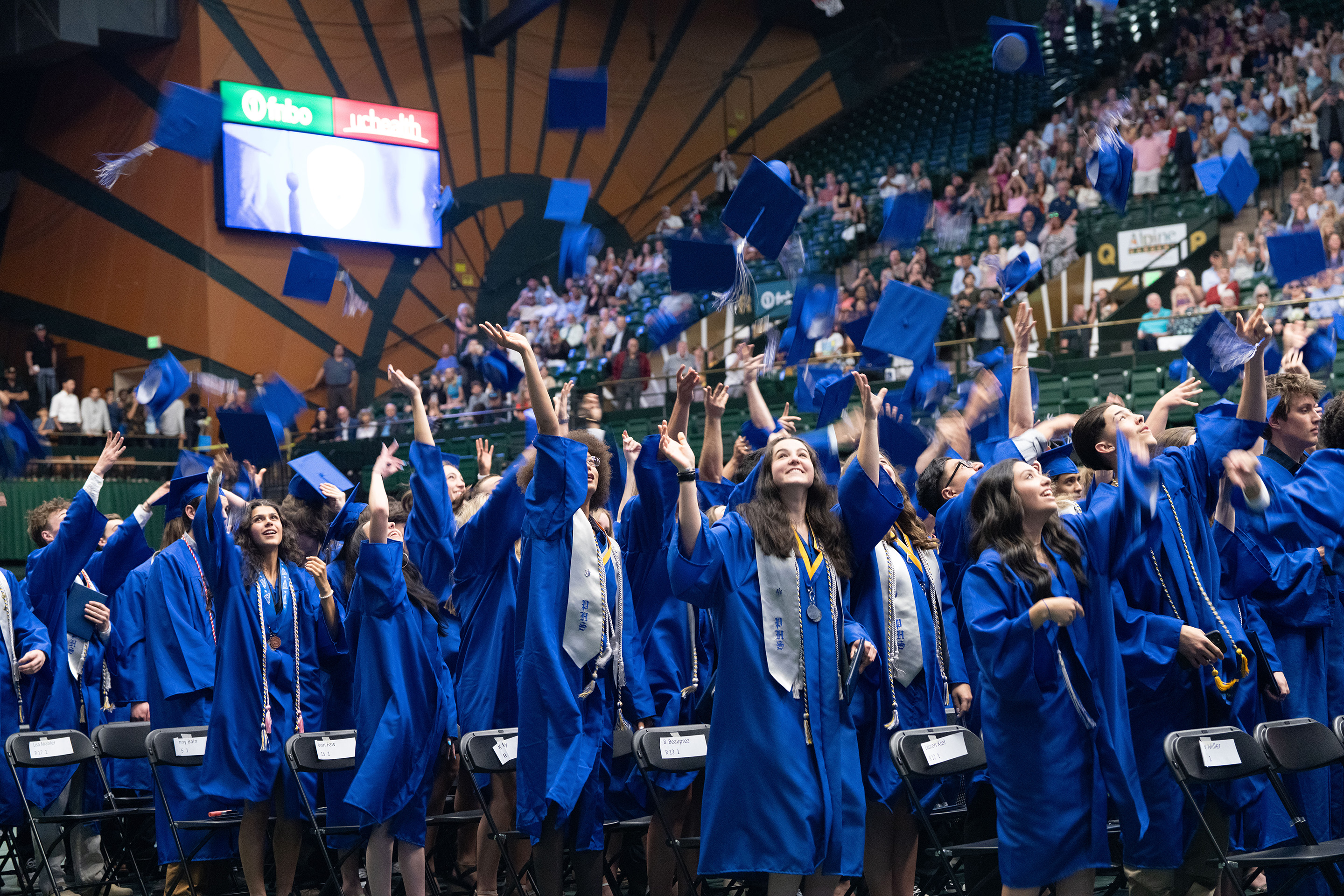 Poudre High School grads throw their caps in the air.