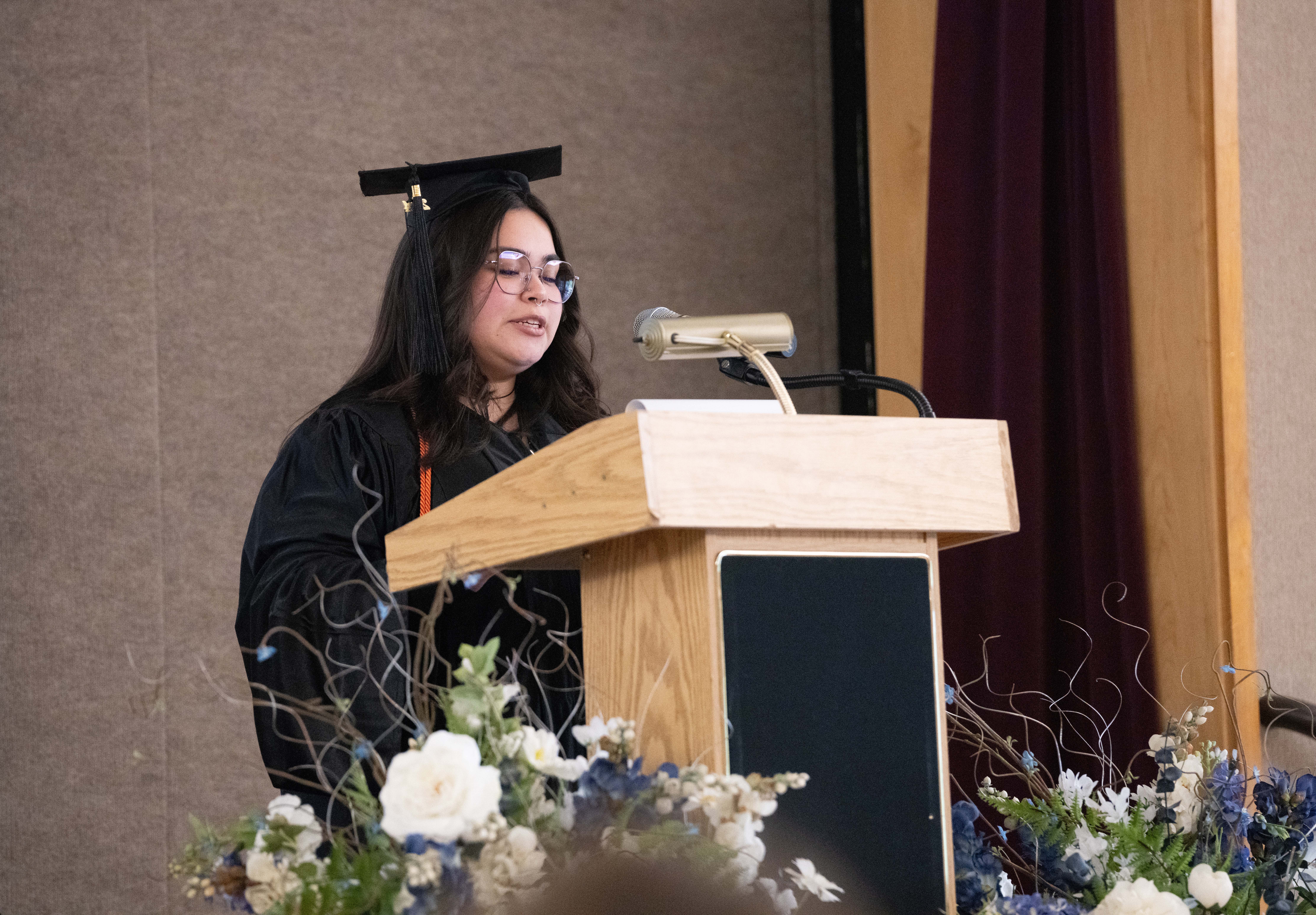 Opportunities Unlimited graduate speaks at the podium.